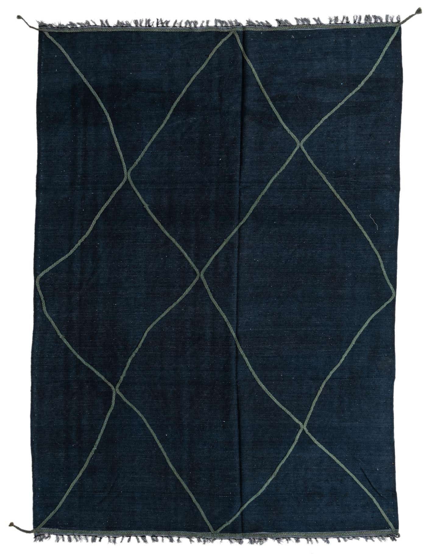 A 7x10 rectangular navy blue wool rug with a light olive green diamond lattice pattern and fringed edges.