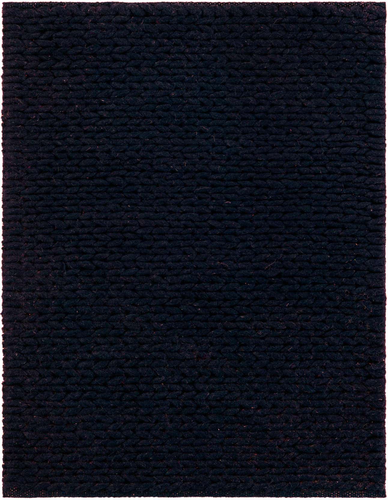 A close-up view of a dark navy blue rectangular rug, showcasing its textured, hand-knitted New Zealand wool pile.