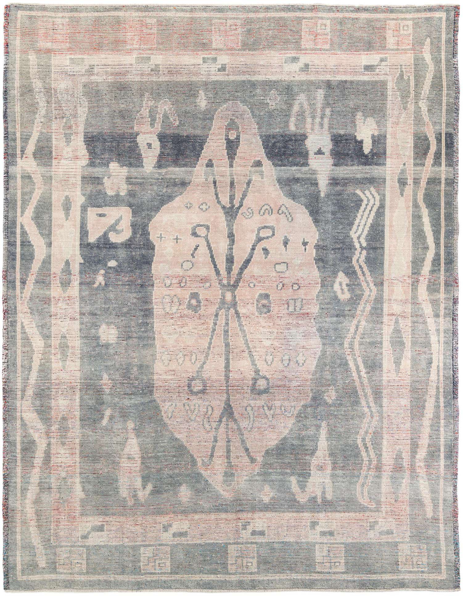 A 9x12 rectangular Moroccan shag rug with a faded navy blue and light pink tribal medallion pattern.