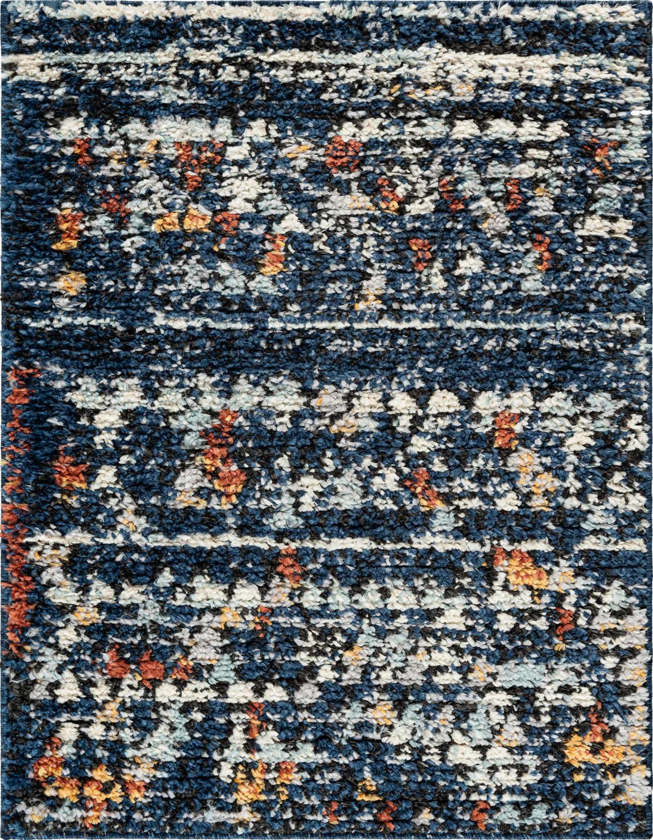 Close-up of a rectangular 2x3 navy blue shag rug with a bohemian tribal pattern in white, black, orange, and yellow.