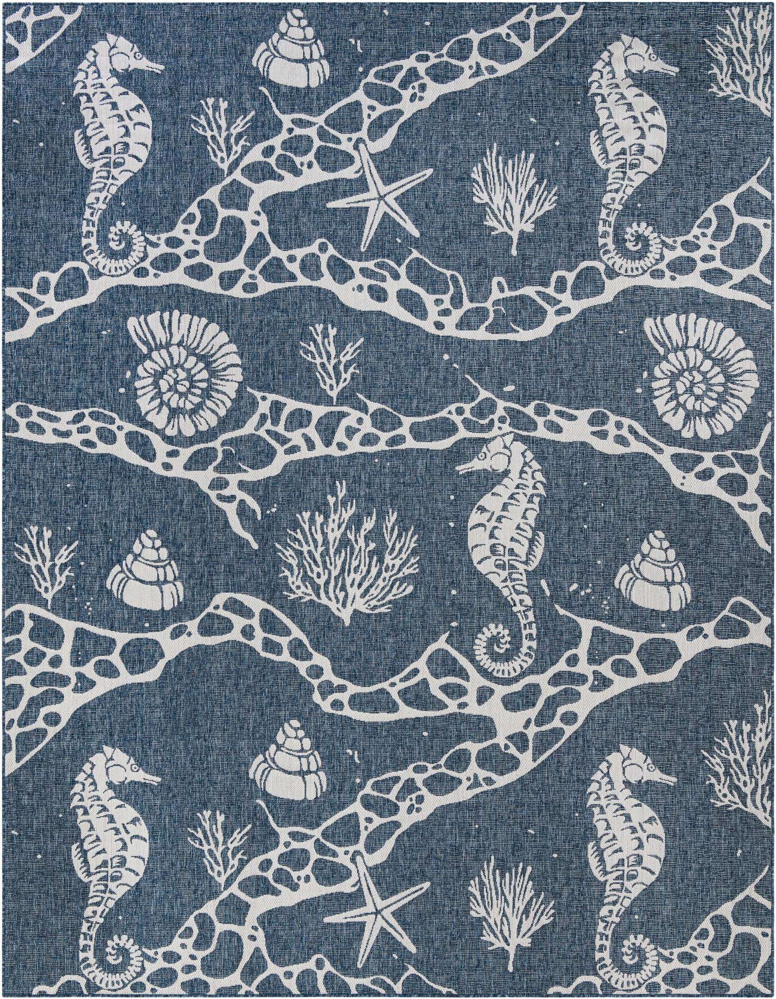 A 9x12 rectangular navy blue indoor/outdoor rug featuring a white coastal pattern of seahorses, starfish, shells, and coral.