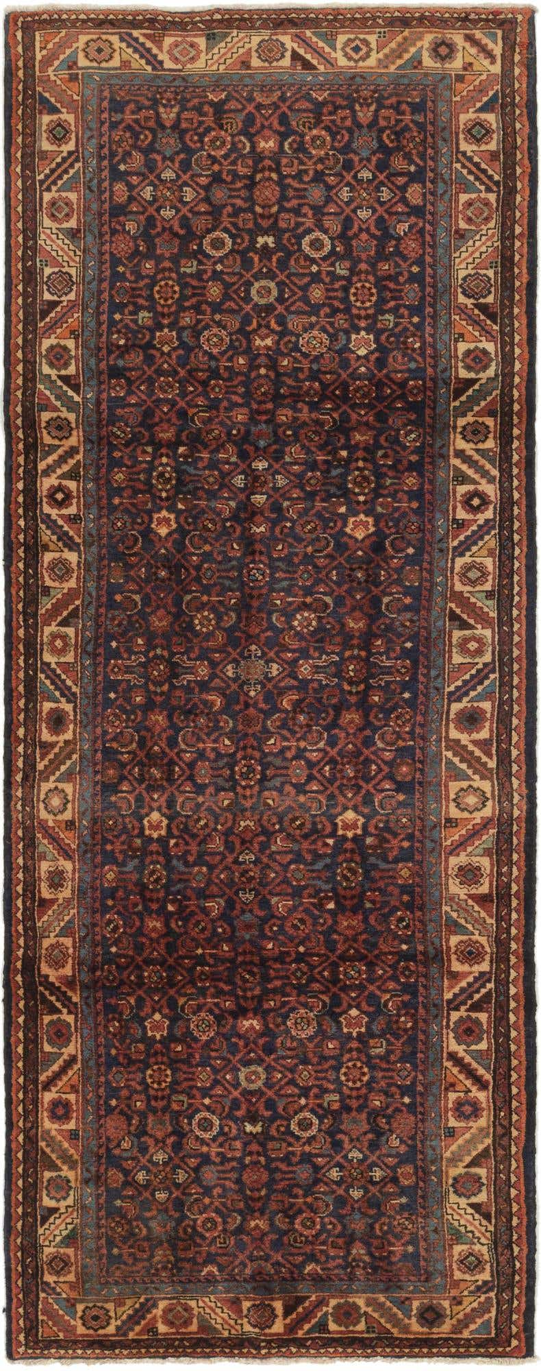 A 10 ft runner rug with a navy blue field and intricate traditional Persian patterns in red, orange, and beige.