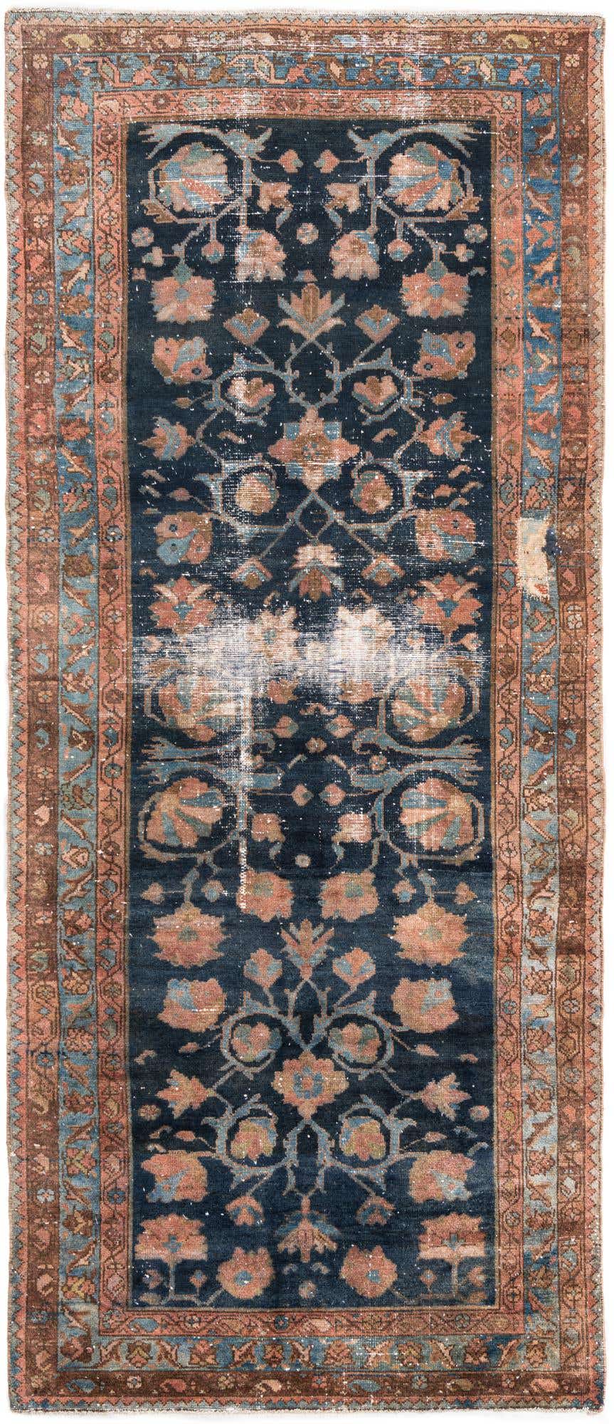 A distressed 10 Ft Ultra Vintage runner rug in navy blue with an intricate Persian floral pattern and light blue and peach accents, ideal for a hallway.
