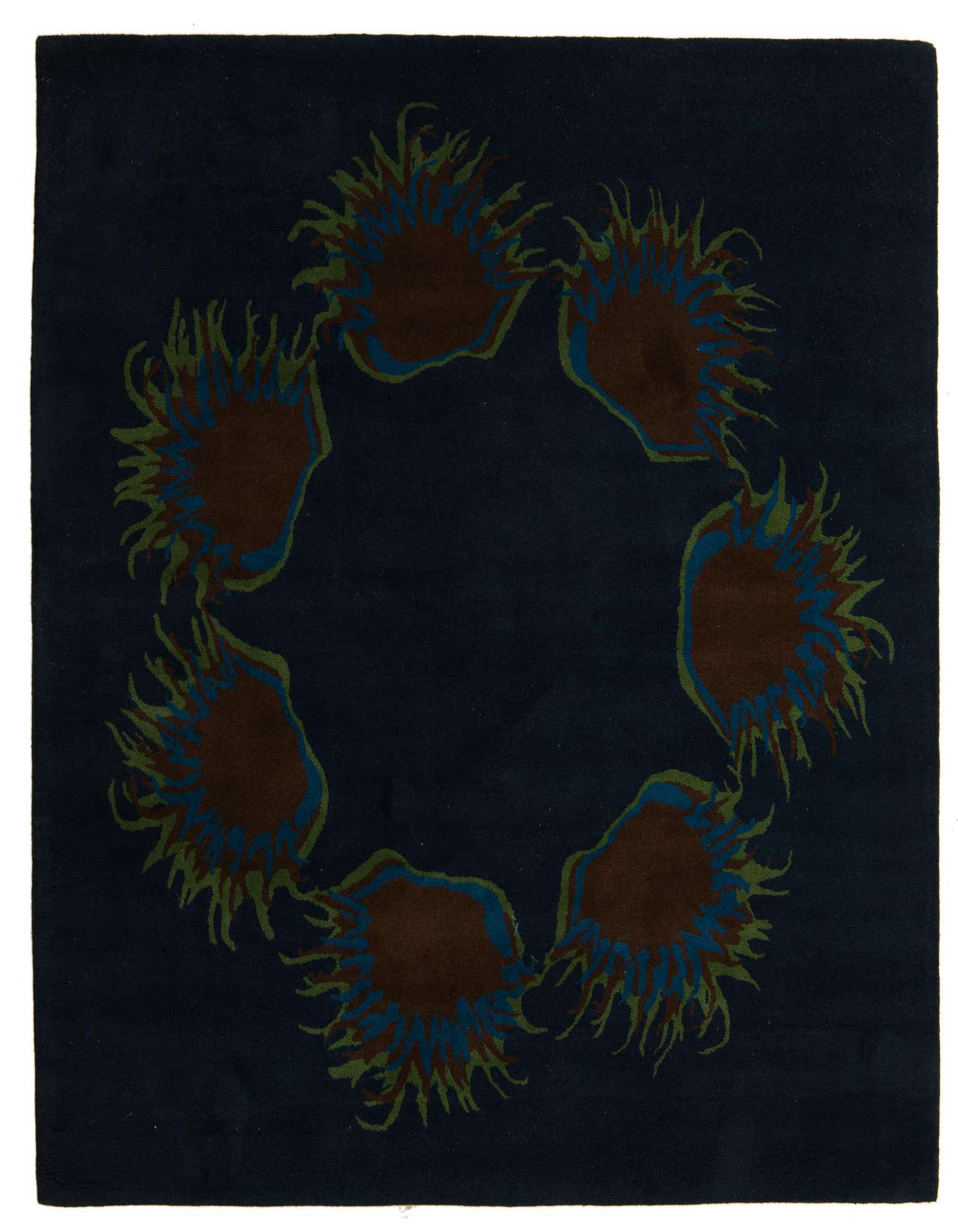 A 7' 6 x 7' 7 square navy blue wool and cotton rug with a modern floral pattern of brown, blue, and green sunburst shapes arranged in a circle.