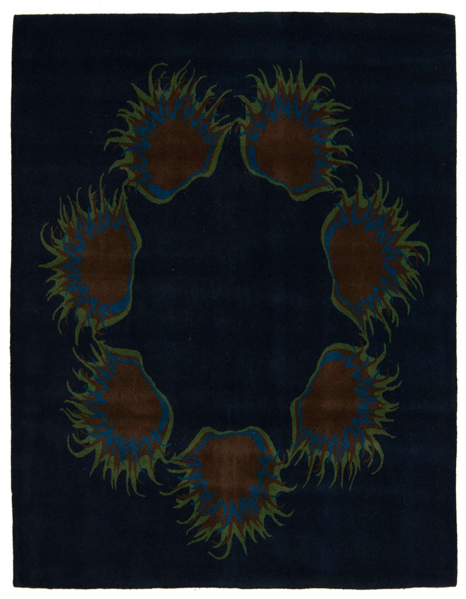 A square navy blue wool and cotton rug with a modern floral pattern of six brown, blue, and green abstract shapes forming a circle.