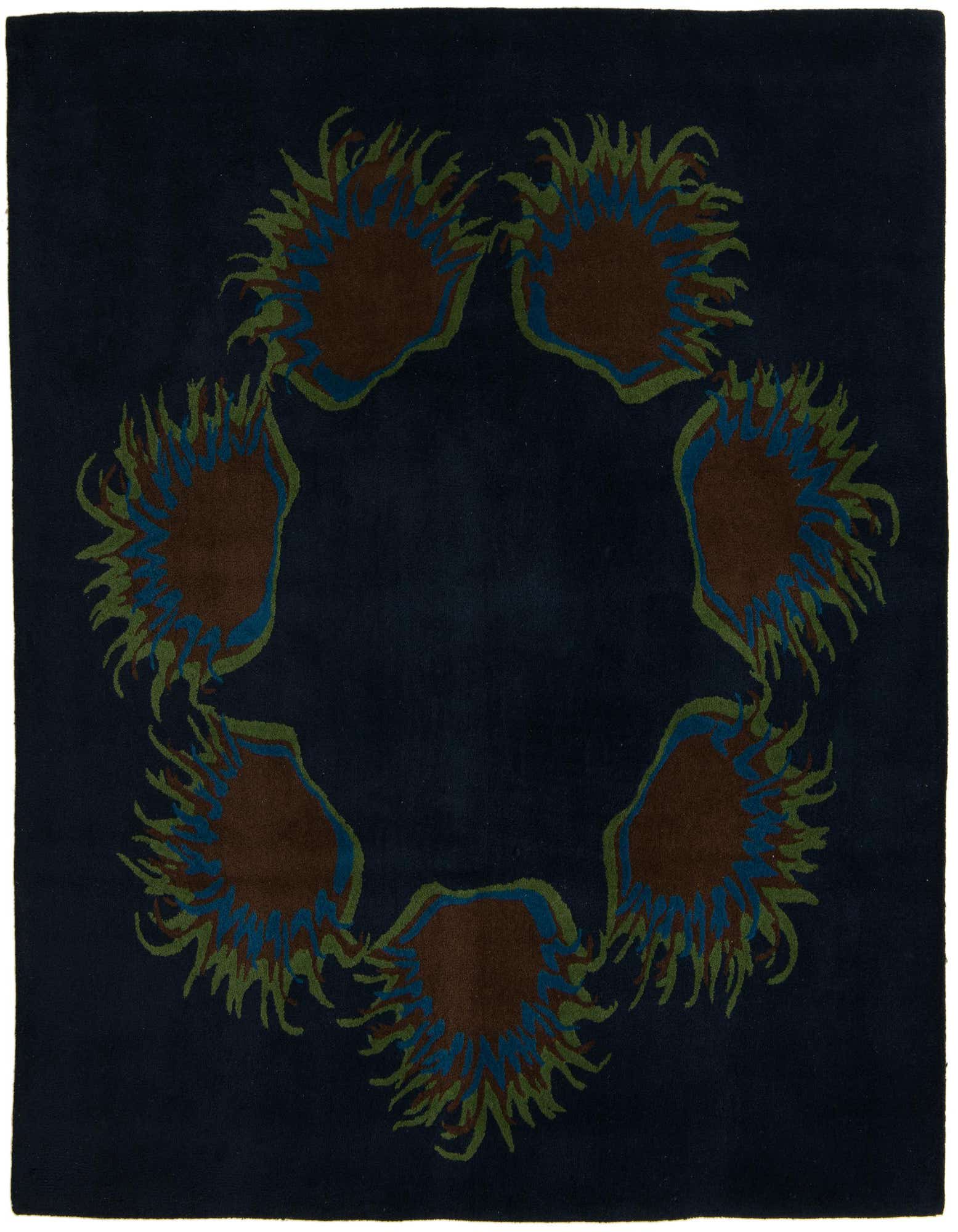 A square navy blue wool and cotton rug with a circular modern floral pattern of brown, blue, and green shapes.