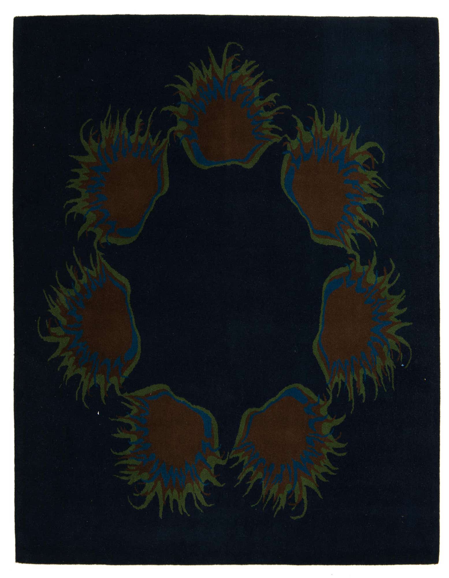 A square navy blue Luna rug with a modern floral pattern of six brown, blue, and green sun-like shapes forming a circle.