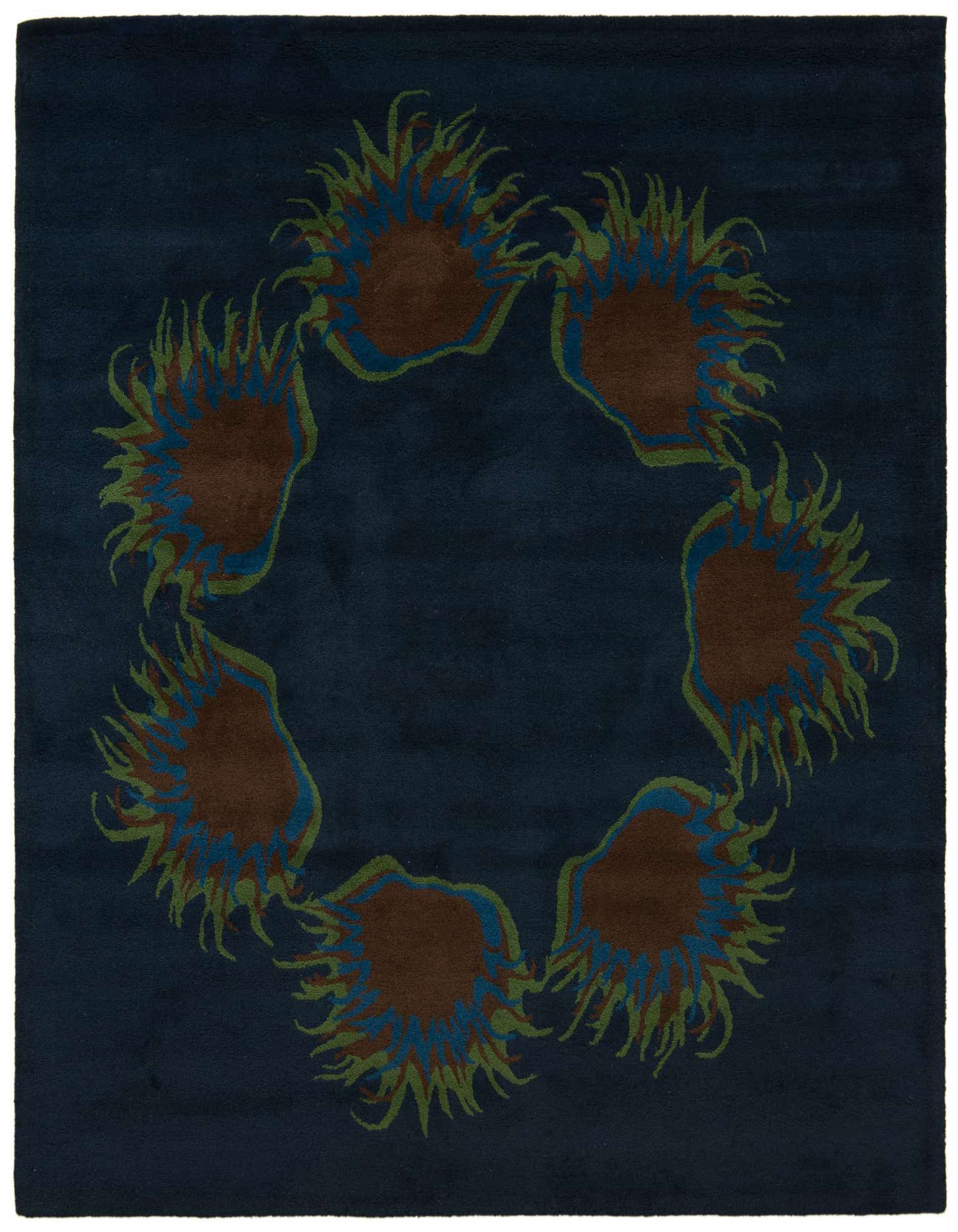 A square navy blue rug with a modern floral pattern of six brown, blue, and green sunburst shapes arranged in a circle.
