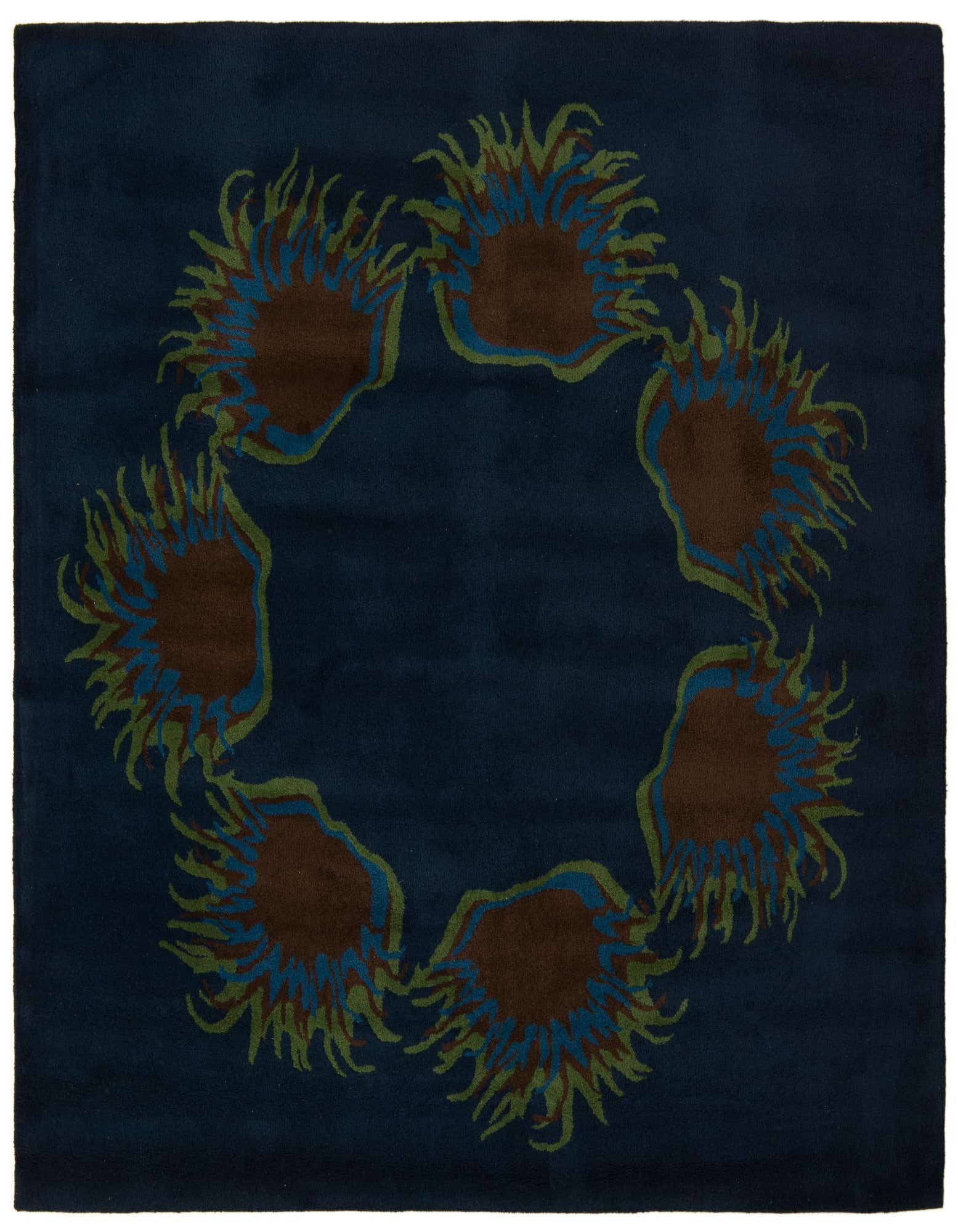 A square navy blue rug with a modern floral pattern of six brown, blue, and green sun-like shapes arranged in a circle.