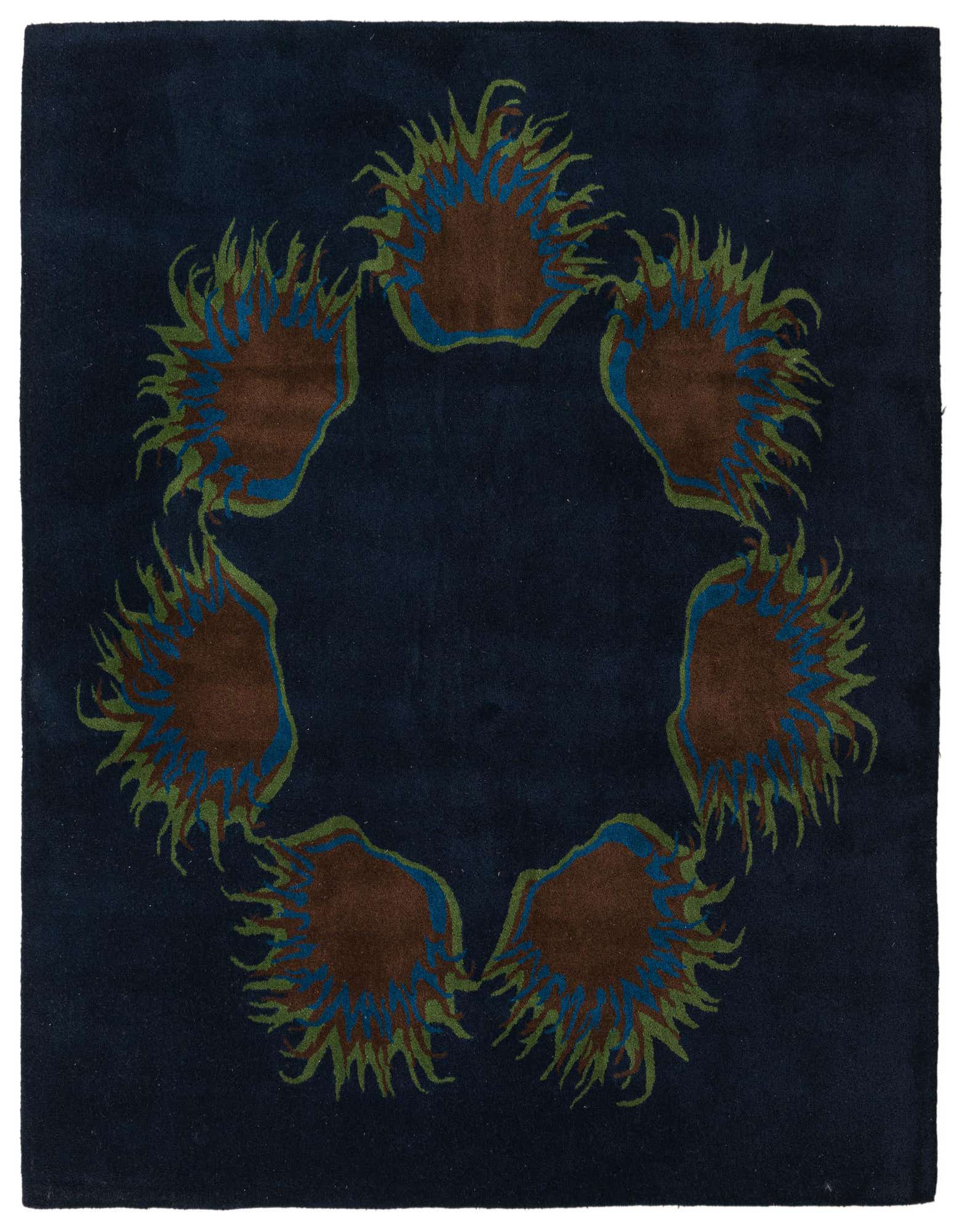 A square navy blue wool rug featuring a circular abstract pattern of six brown, blue, and green spiky shapes.