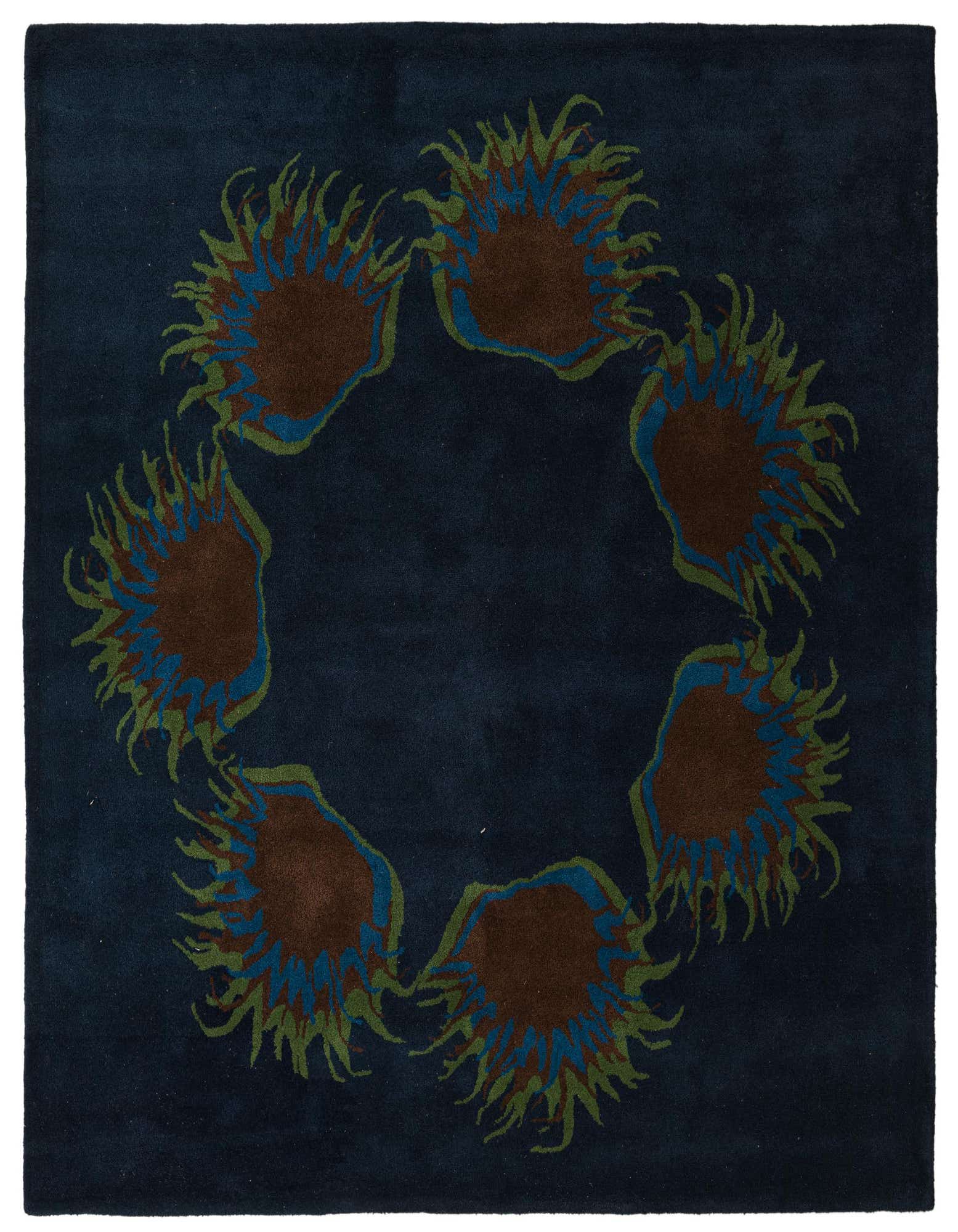 A square navy blue wool rug featuring a circular botanical pattern of brown, blue, and green floral shapes.
