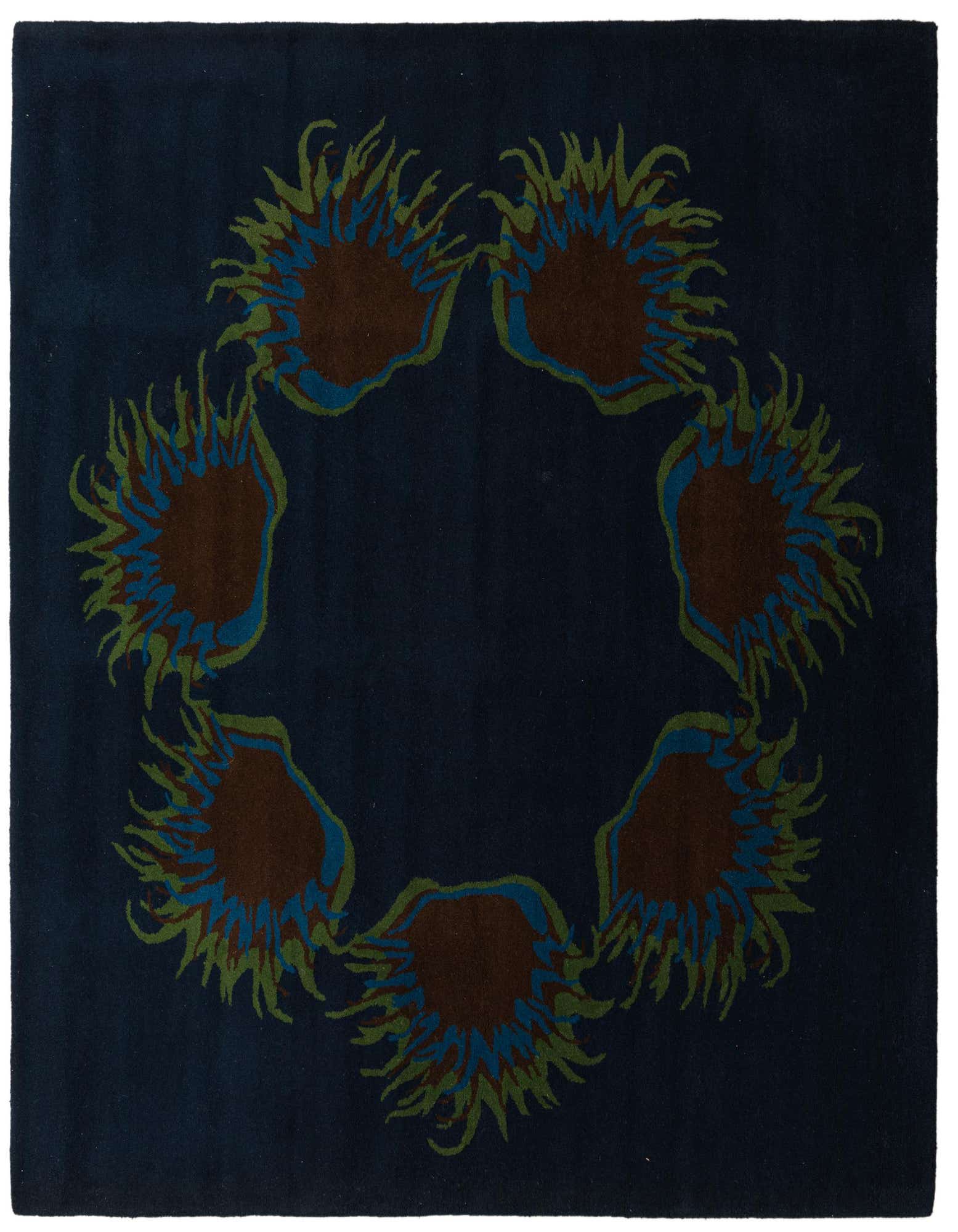 A square navy blue wool rug featuring a circular arrangement of abstract floral patterns in brown, blue, and green.