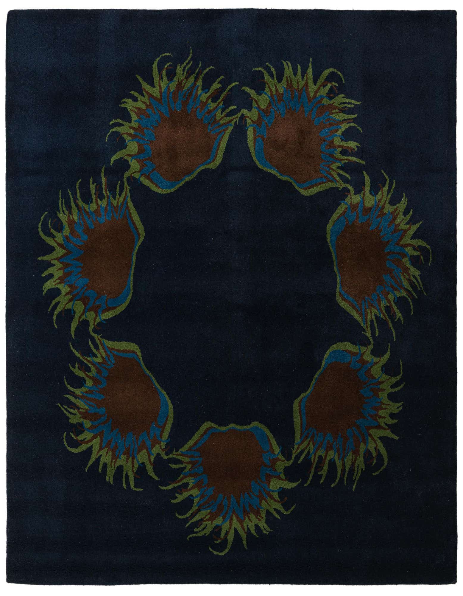A square navy blue wool rug featuring a circular arrangement of abstract floral designs in brown, teal, and olive green.