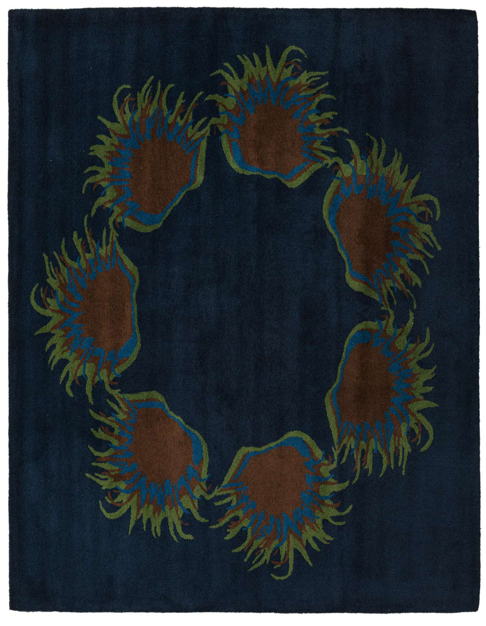 A square navy blue wool rug featuring a circular botanical pattern of brown, green, and blue floral shapes.