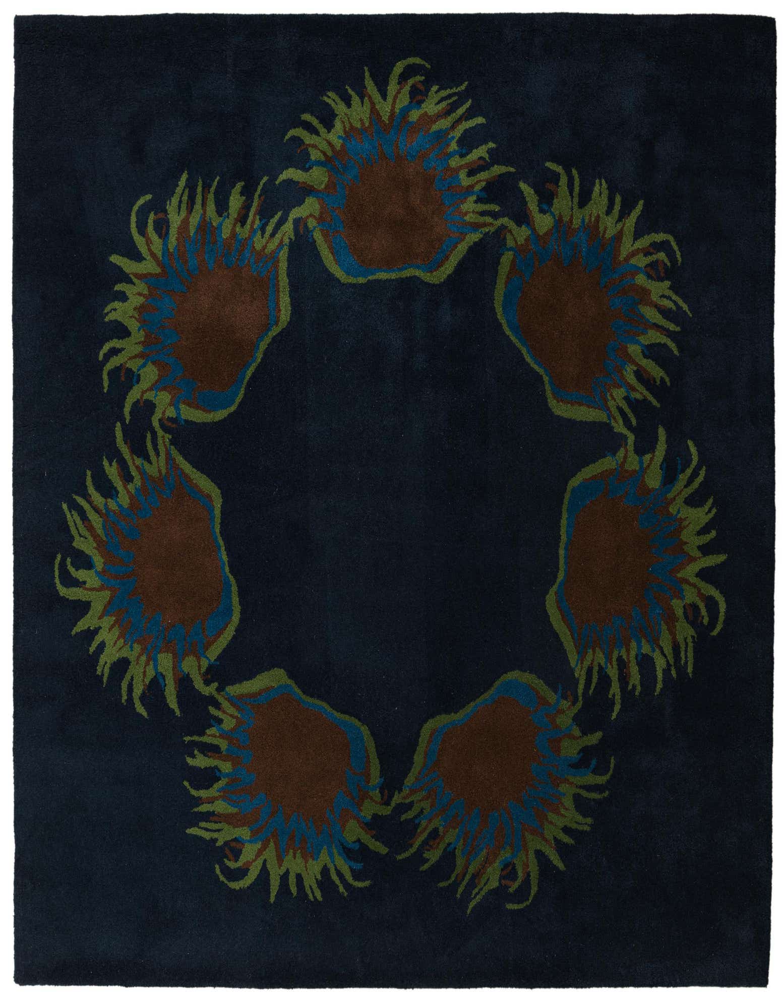 A square navy blue wool rug featuring a circular botanical pattern of brown, teal, and olive green floral shapes.