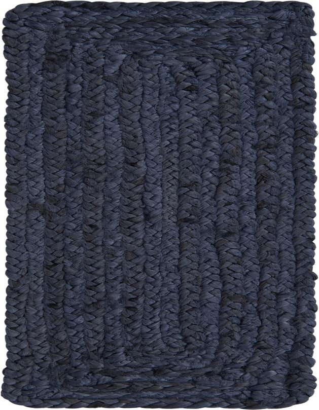 A close-up view of a dark navy blue braided jute stair rug, showcasing its textured, flatweave construction.