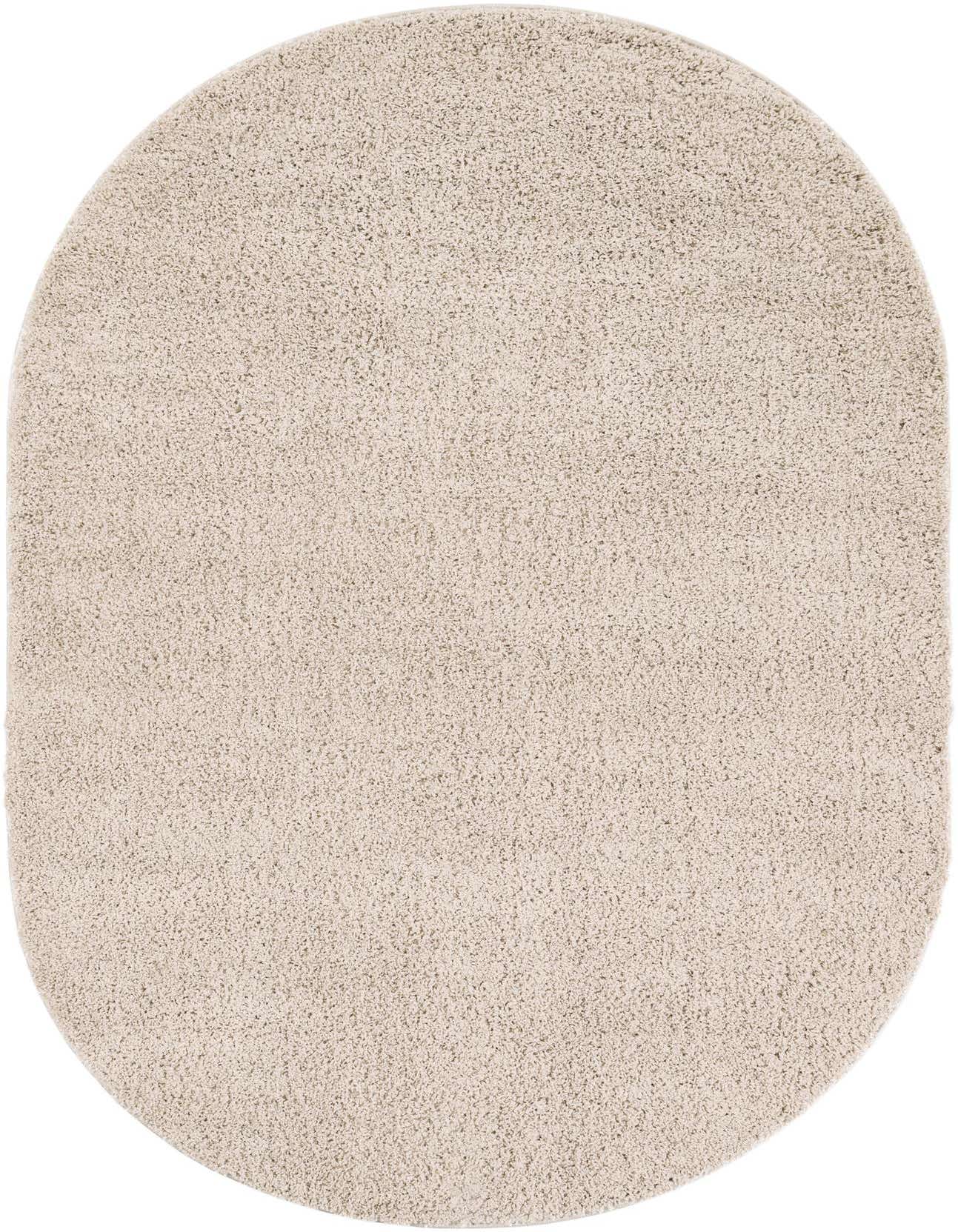 A plush 5' 3 x 8' 0 oval ivory shag rug with a textured pile, ideal for adding soft comfort to any indoor space.