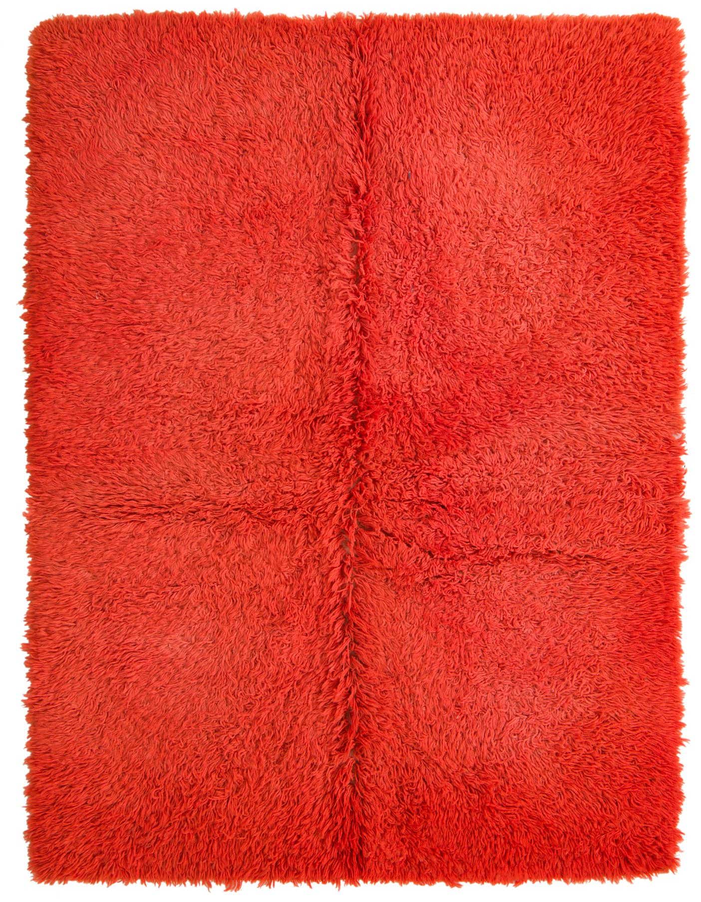 A vibrant 5x8 rectangular orange shag rug, handmade from wool, offering a plush texture for a modern living room.
