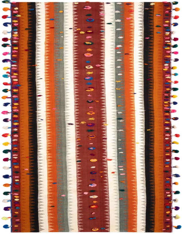 A vibrant Jajim 11 ft runner rug with vertical stripes in orange, black, white, and grey, featuring colorful pom-pom accents and tassels along the edges, perfect for a hallway.