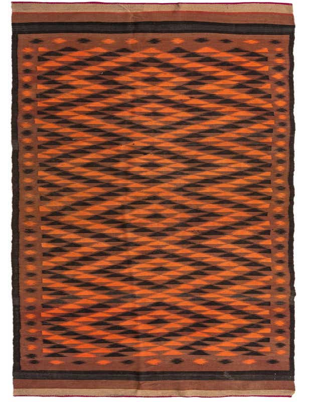 A 16 ft runner rug with a vibrant orange and dark brown tribal geometric pattern, featuring a flatweave texture.