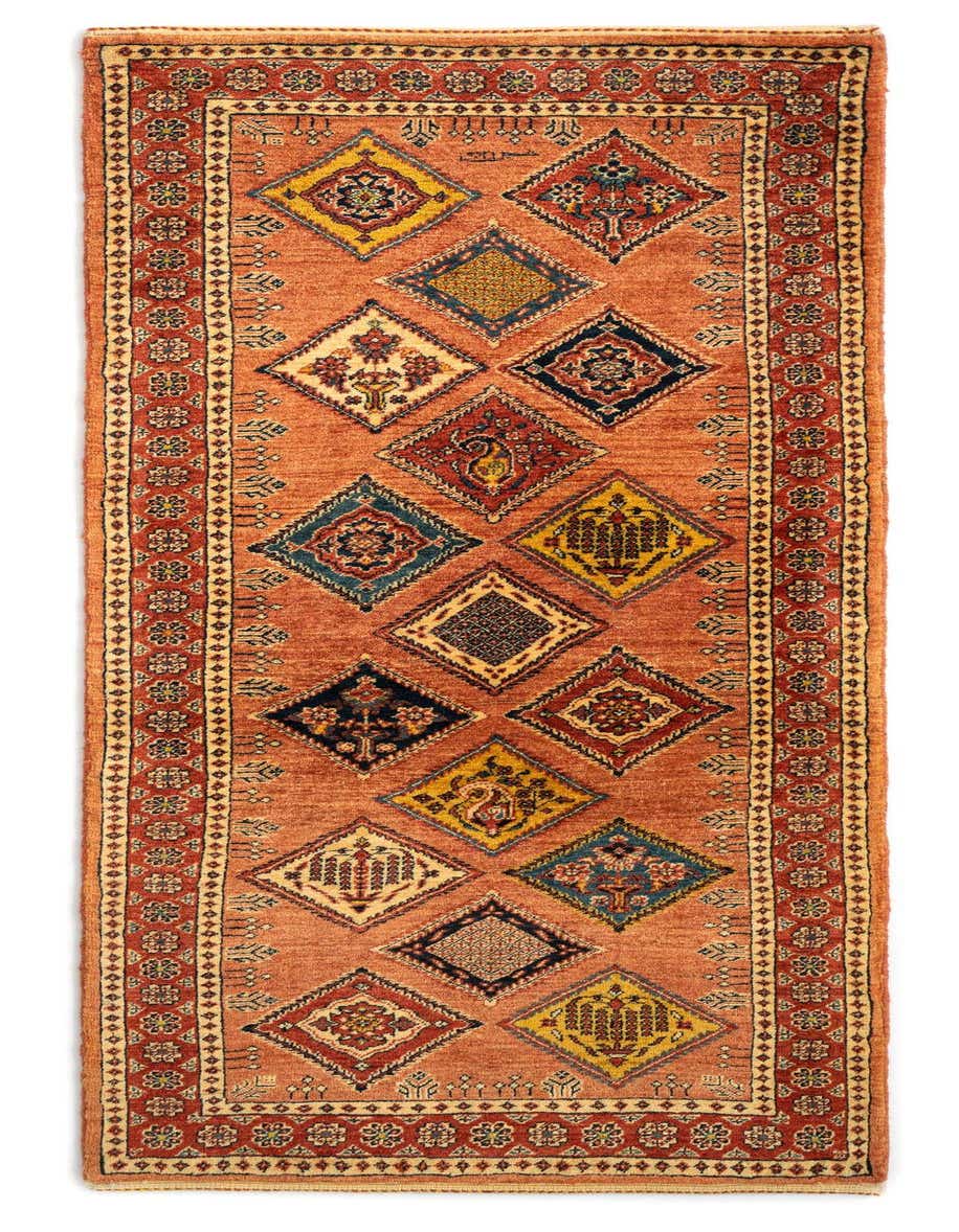 A 7 ft runner rug in orange with a traditional Persian pattern of colorful diamonds and a detailed border.