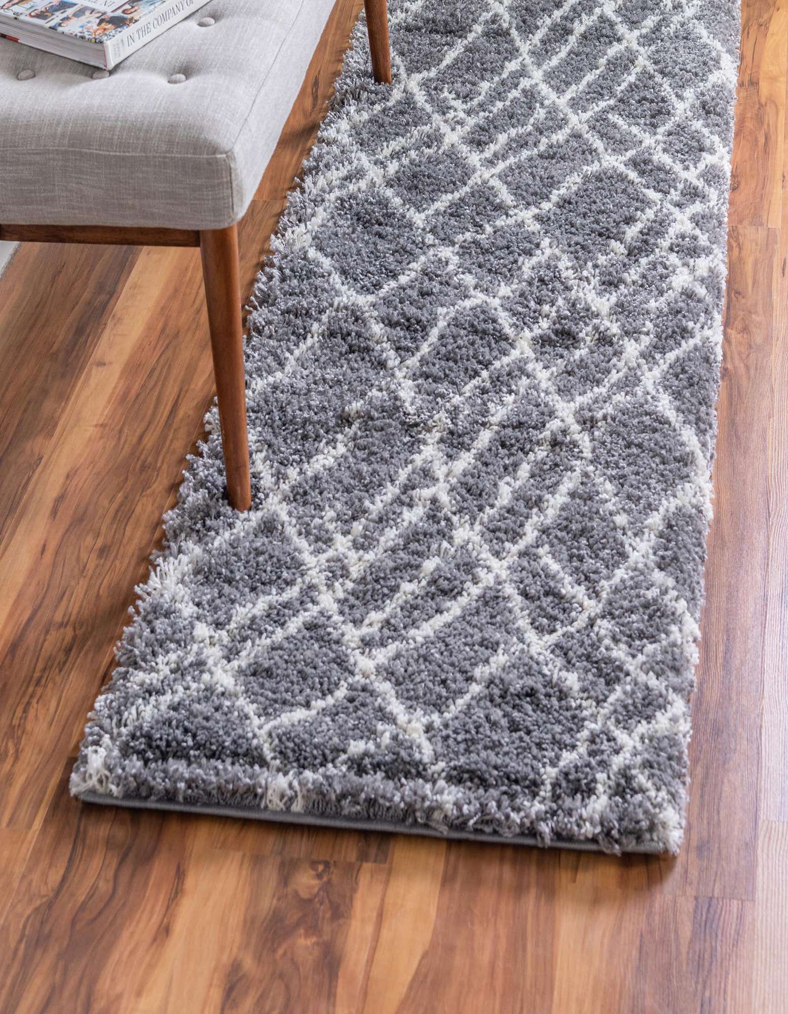 A gray shag runner rug with a white geometric diamond pattern, featuring a soft, textured pile.