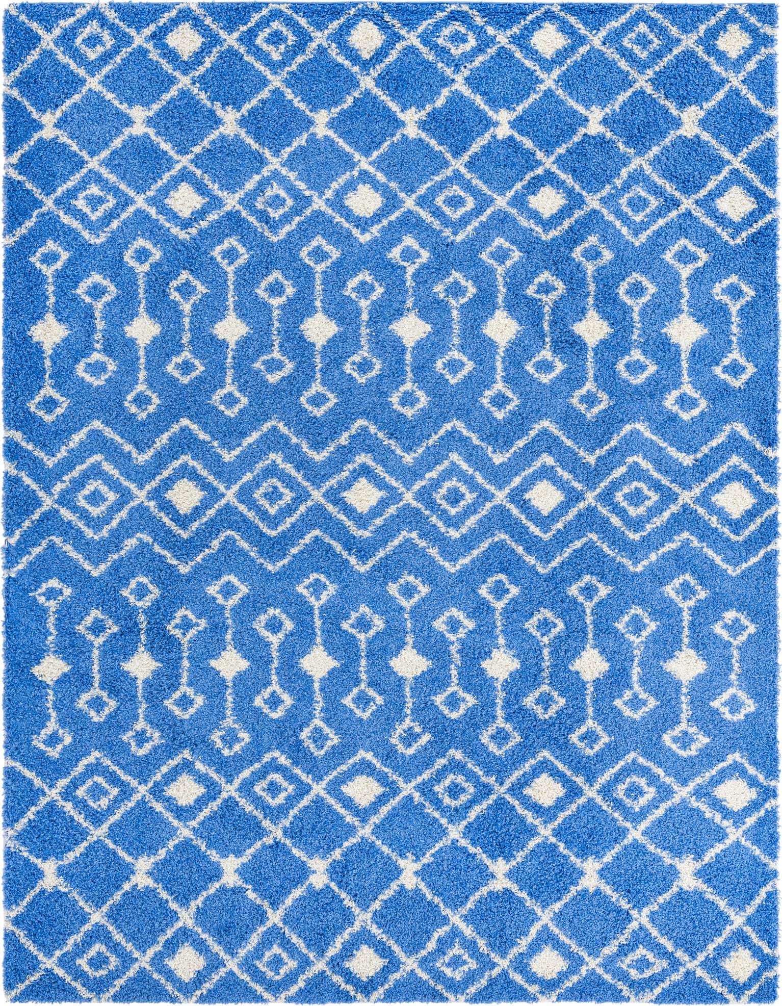 A 10x13 rectangular blue shag rug with a white tribal geometric pattern, featuring diamonds and zigzags.