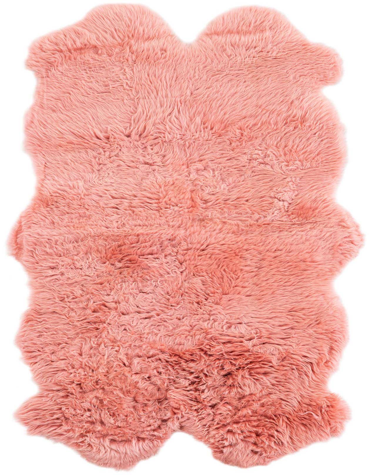 A plush, freeform pink lambskin rug with a medium pile, perfect for adding warmth and texture to an indoor space.