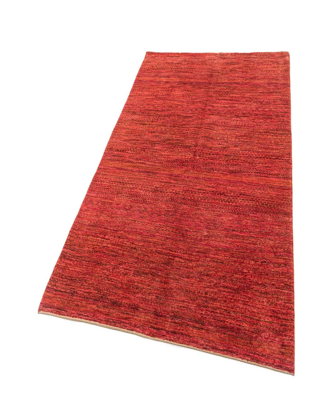 A 5x8 rectangular handmade wool rug in varying shades of pink, featuring a textured, striped pattern, suitable for an indoor living space.