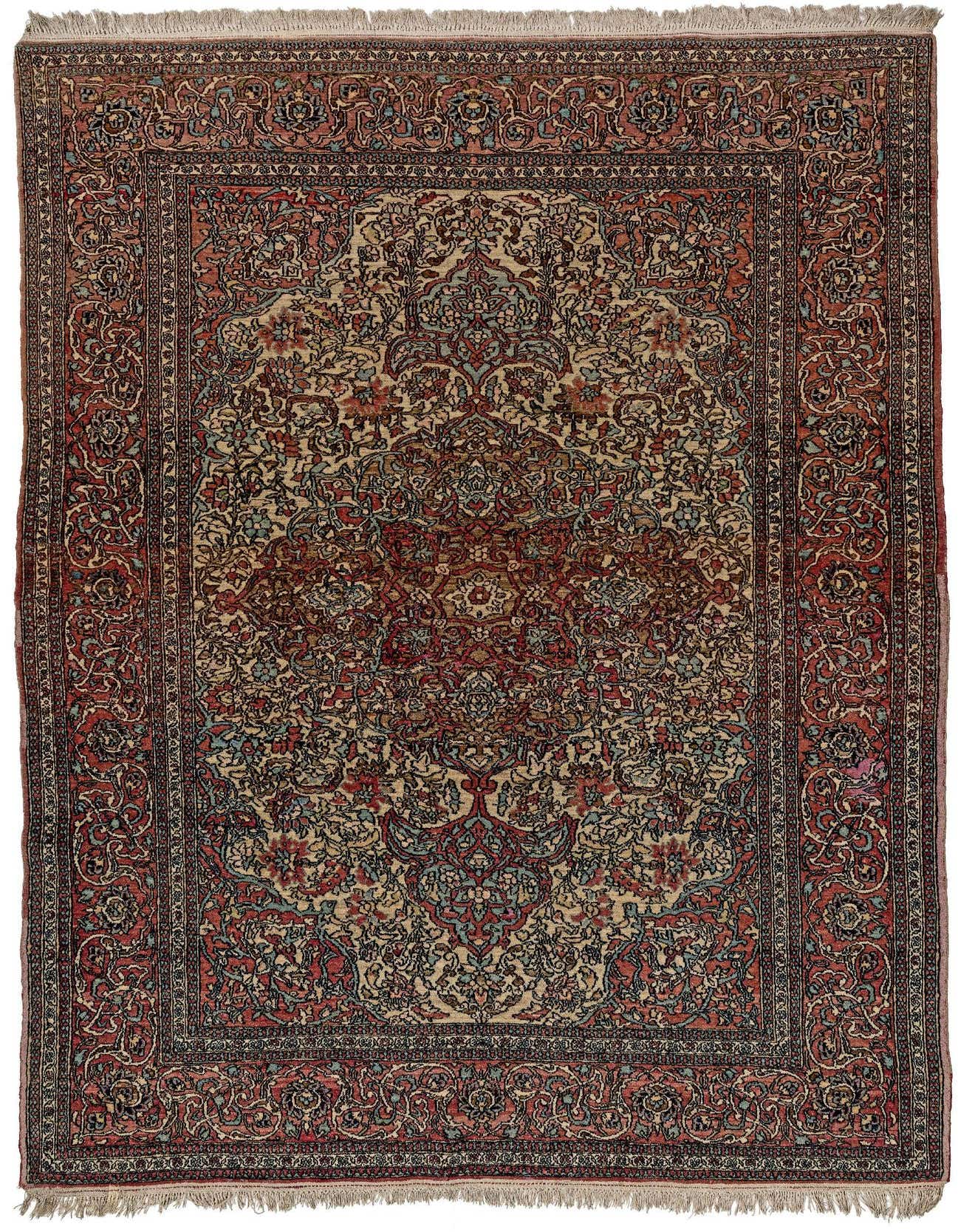 A 5x8 rectangular handmade wool rug with a complex traditional pattern in shades of pink, red, blue, and cream, featuring a central medallion and ornate border.