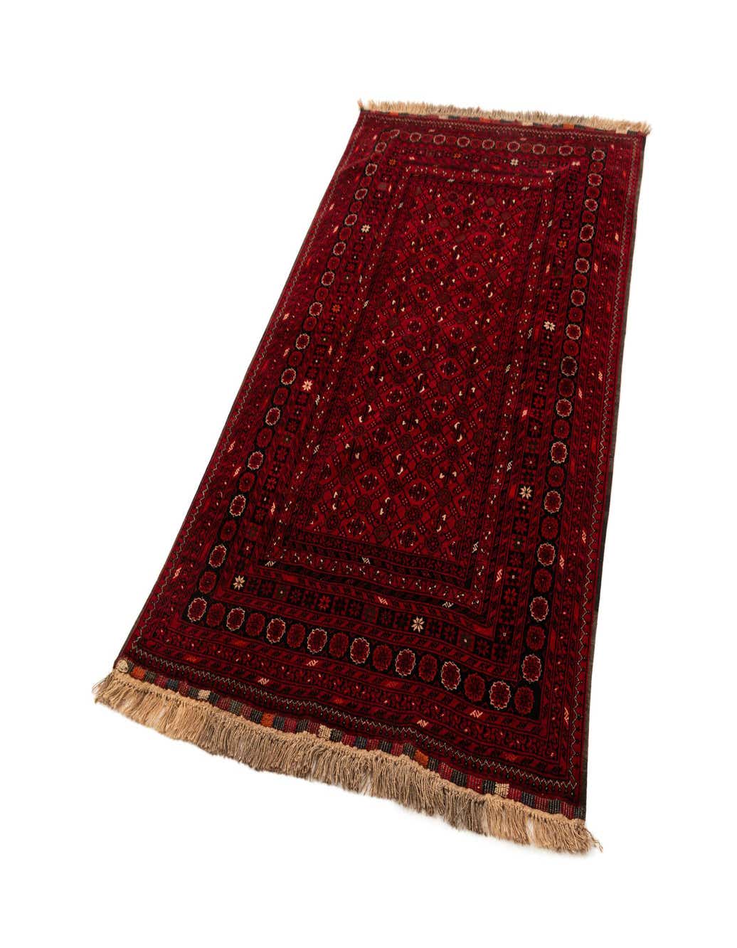 A 4x6 rectangular red tribal Afghan rug made of sheep virgin wool, featuring intricate patterns and fringe.