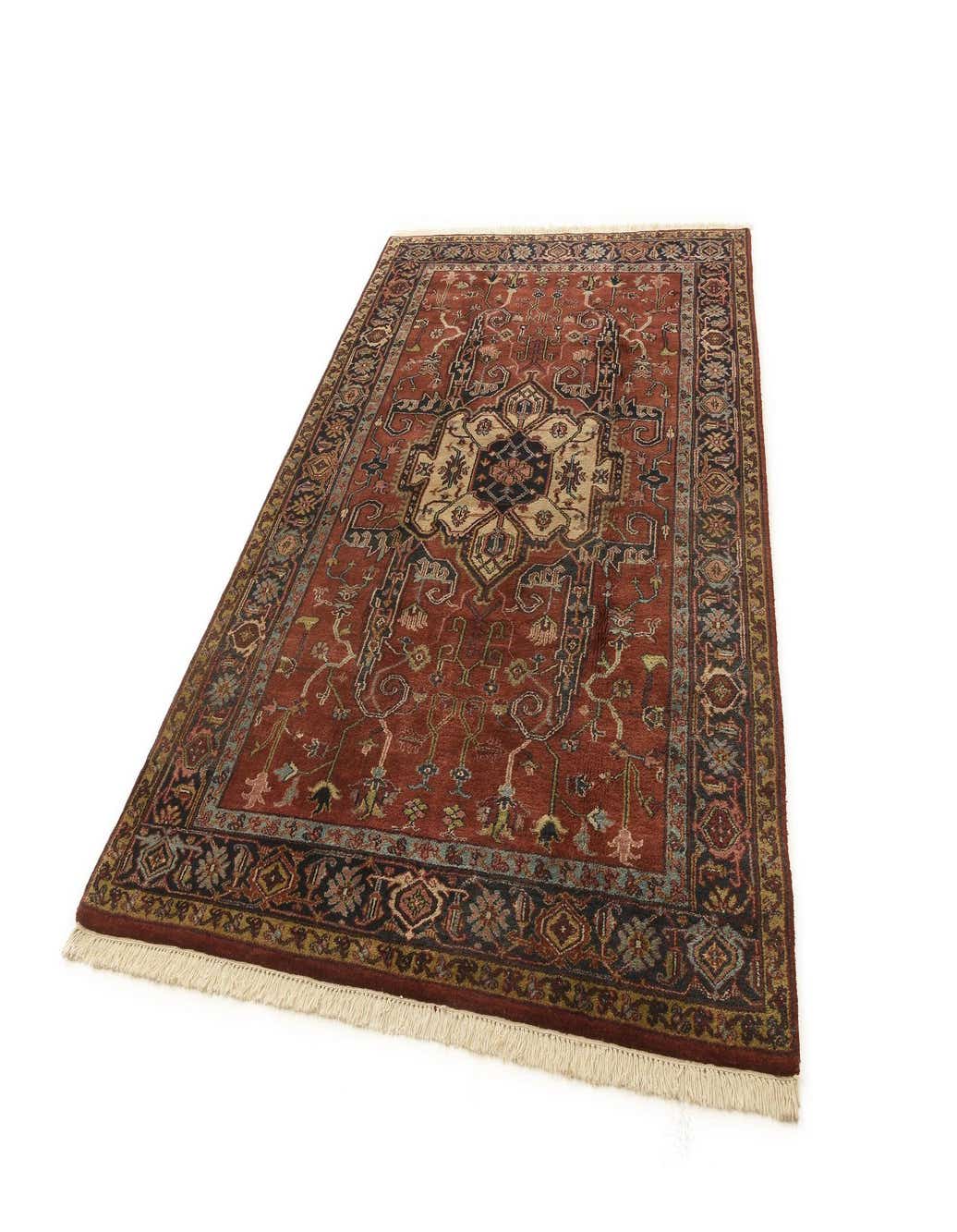 A 6x9 rectangular red wool rug with a detailed traditional pattern and fringed ends, suitable for a living room.