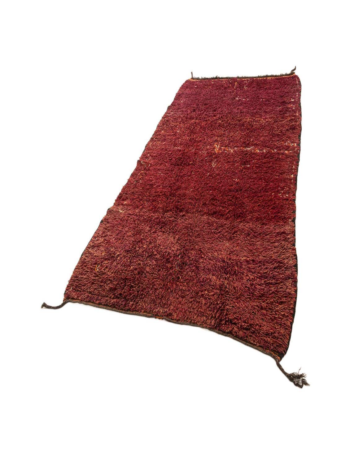 A 6x9 rectangular handmade Berber wool rug in rich red tones with a medium pile, ideal for a living room.