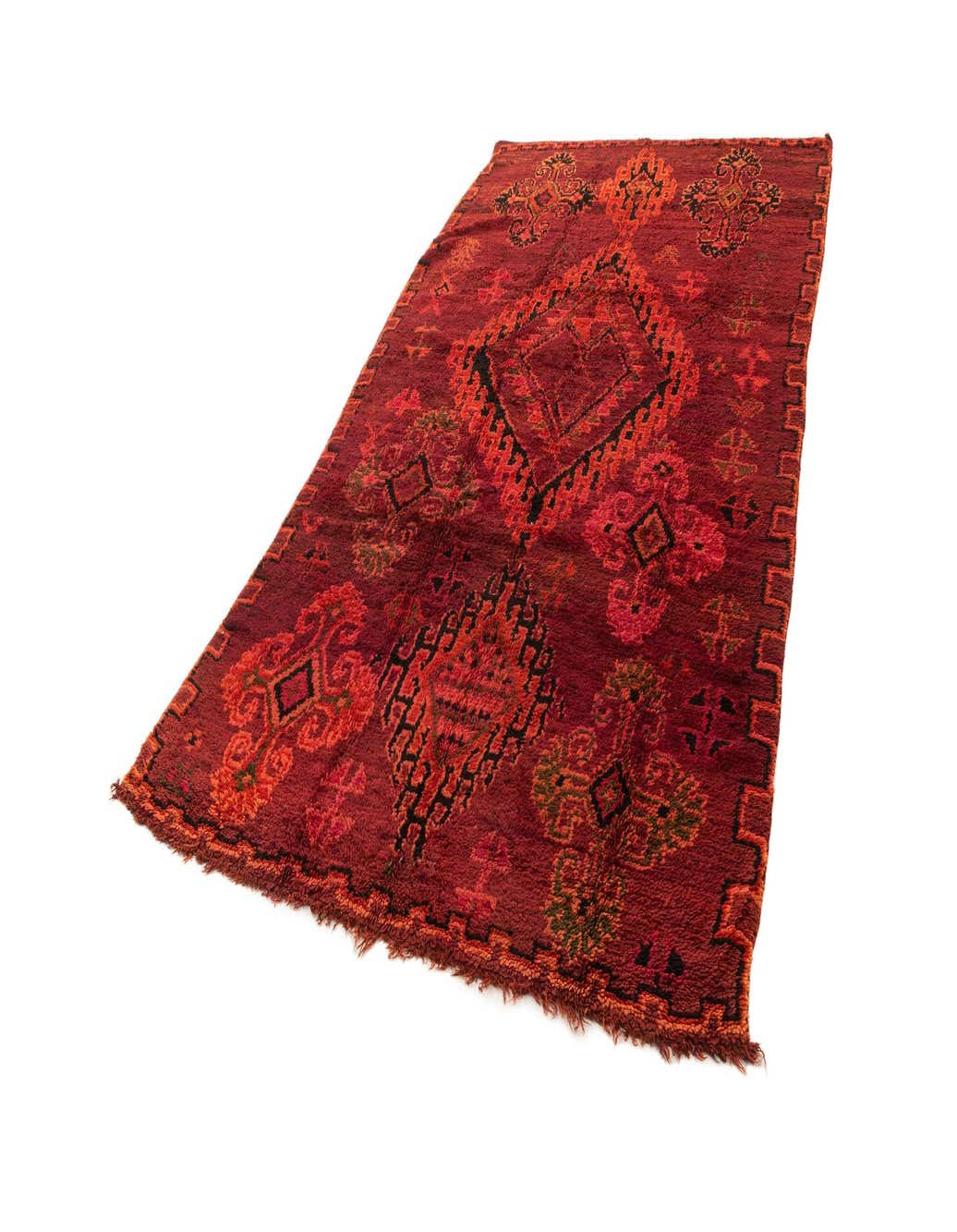 A 6x9 rectangular handmade Berber wool rug in various shades of red with intricate geometric patterns.