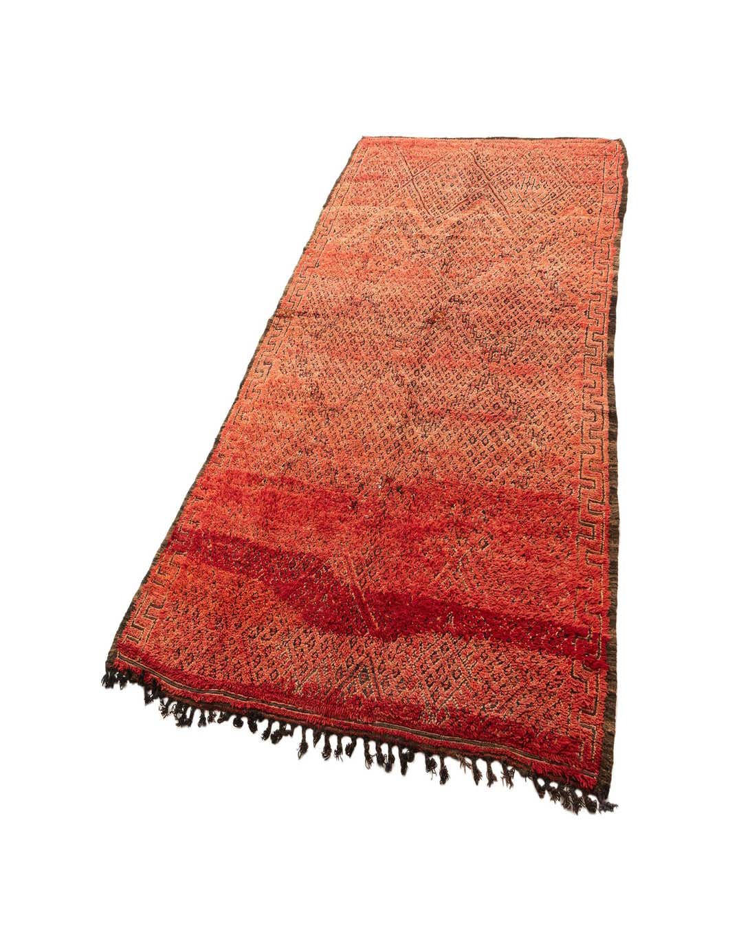 A 6x9 rectangular handmade Berber wool rug in shades of red with subtle geometric patterns and fringe.
