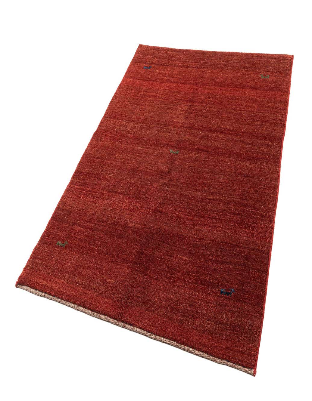 A 4x6 rectangular Gabbeh Shouli rug in varying shades of red sheep virgin wool with small, subtle blue and green accents.