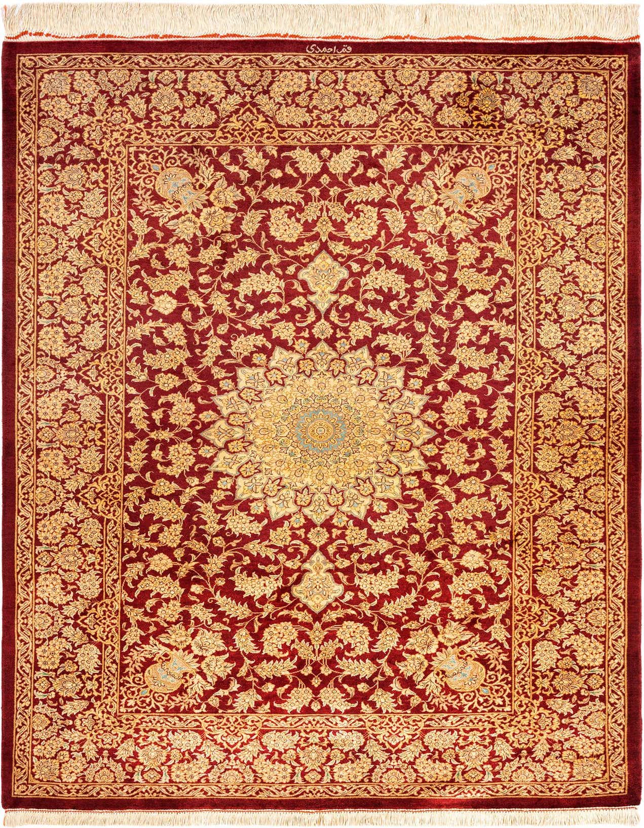 A luxurious 3x5 rectangular Ghom Silk Persian rug in deep red with intricate gold floral patterns and a central medallion, featuring white fringe.