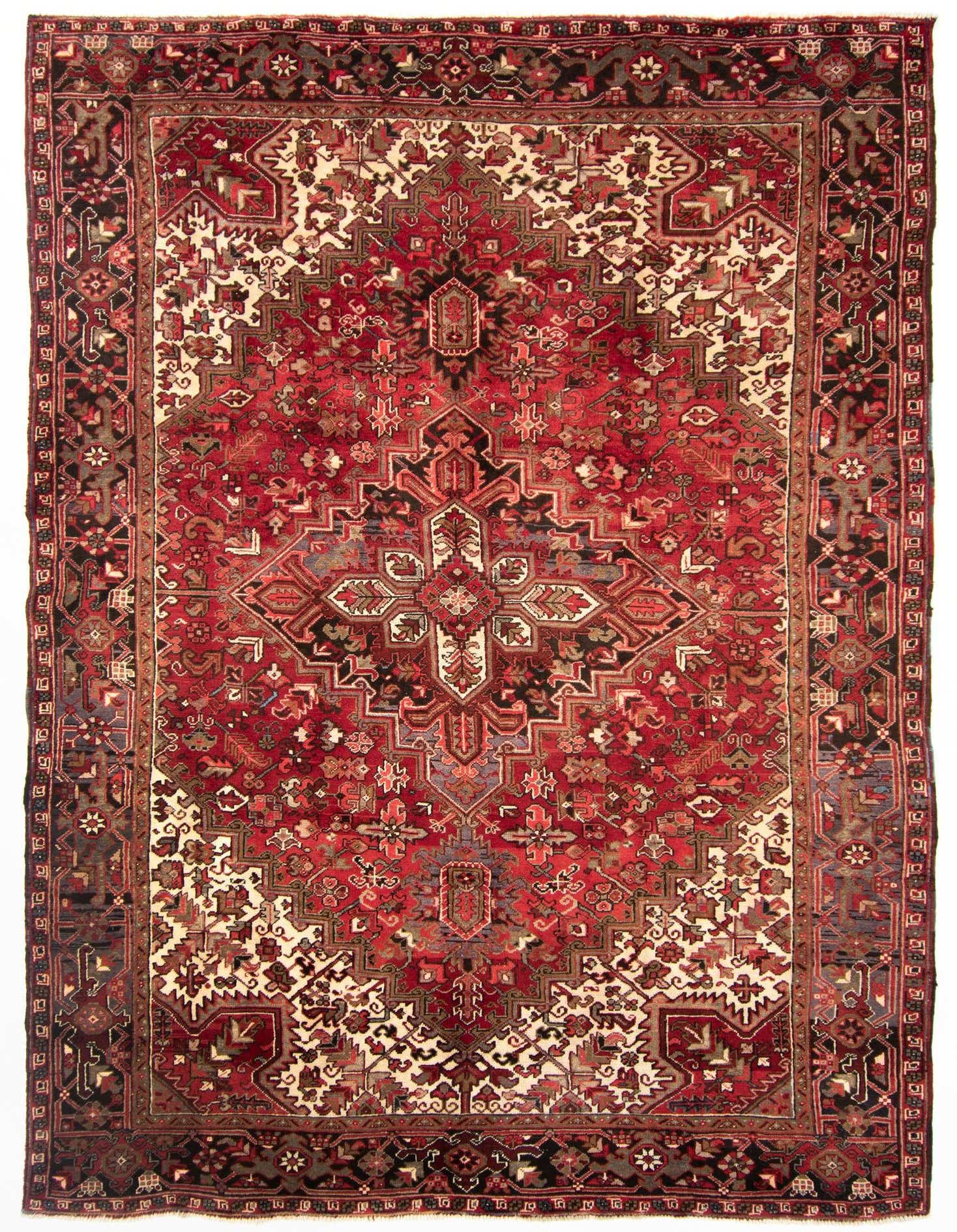 A rectangular 8x11 red Persian Heriz rug with intricate geometric and floral patterns in cream, black, and blue.