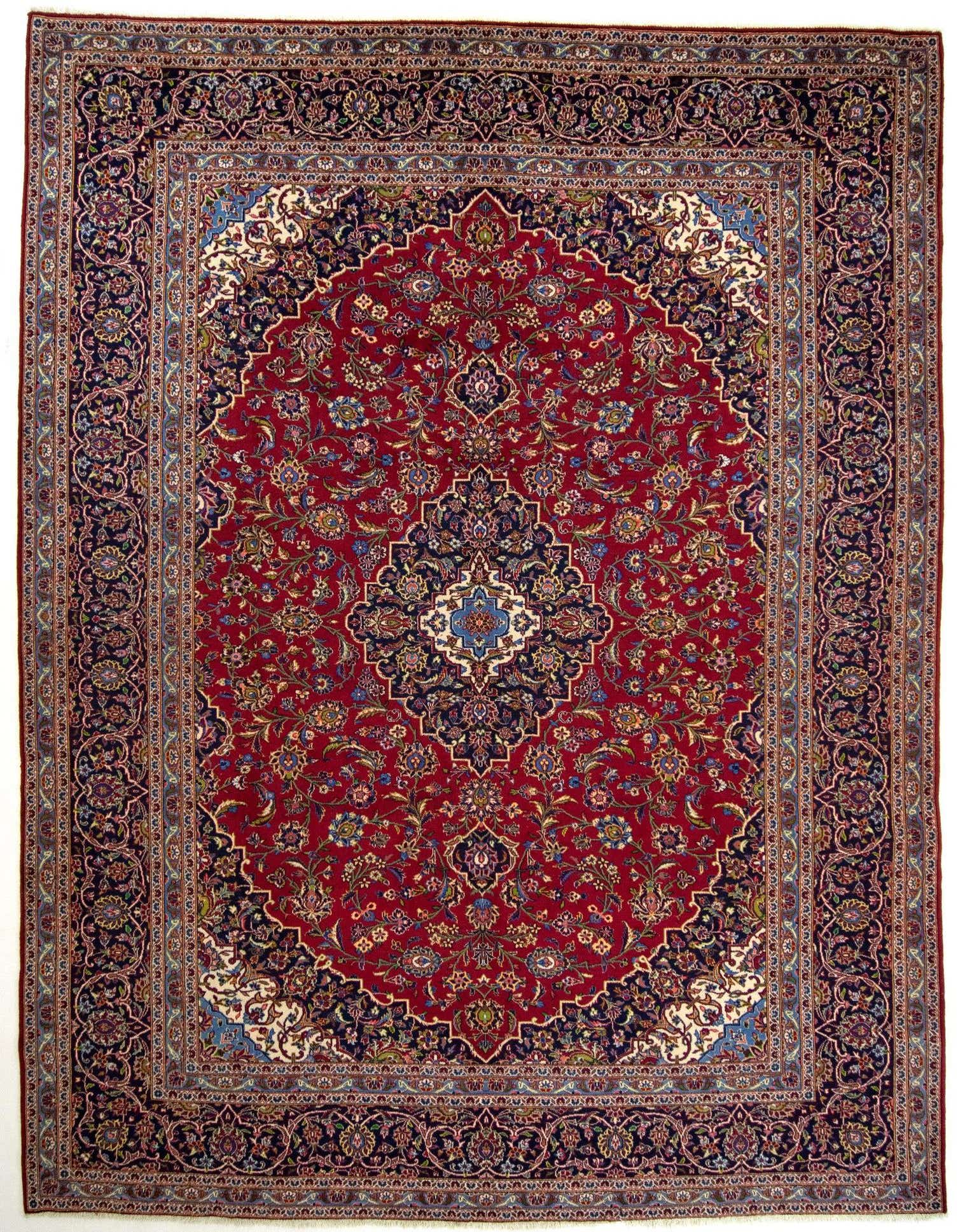 A 10x13 rectangular red Persian rug with intricate floral patterns and a dark blue border, suitable for a living room.