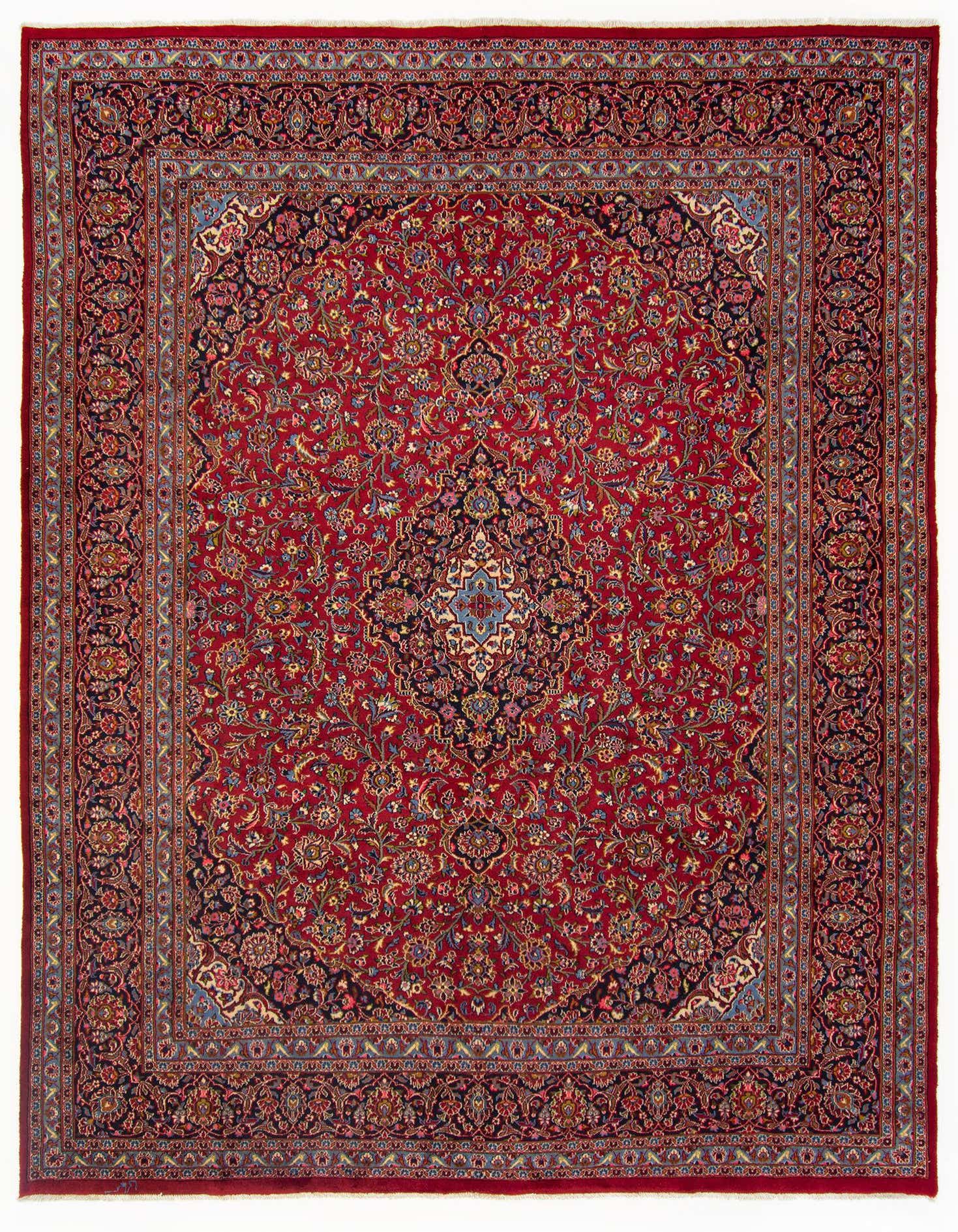 A 10x12 rectangular Kashan Persian rug in deep red with intricate floral and medallion patterns, featuring navy, gold, and light blue accents.