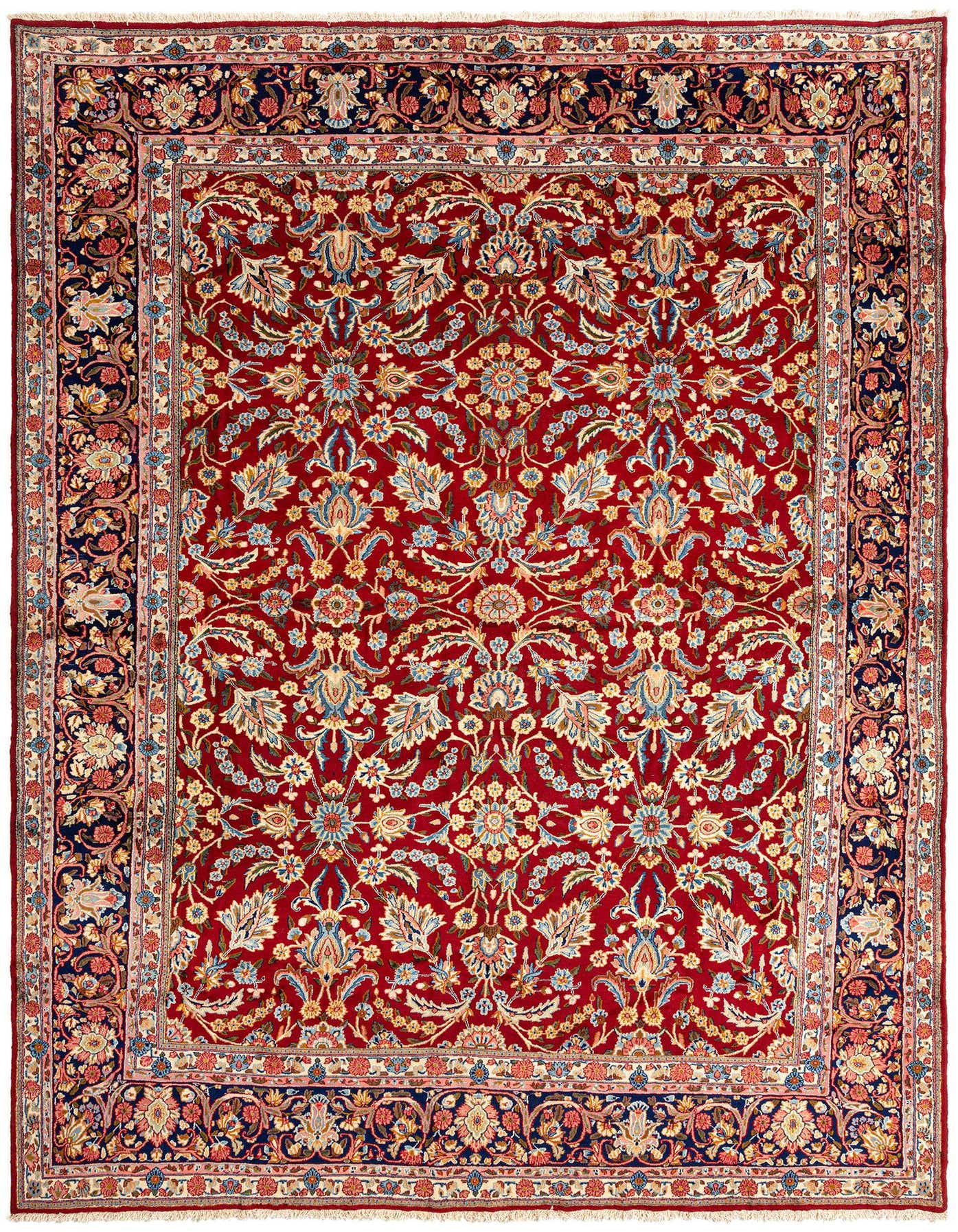 A large 10x14 rectangular Kerman Persian rug with a rich red field and intricate floral patterns in blue, gold, and cream, framed by a dark blue border.