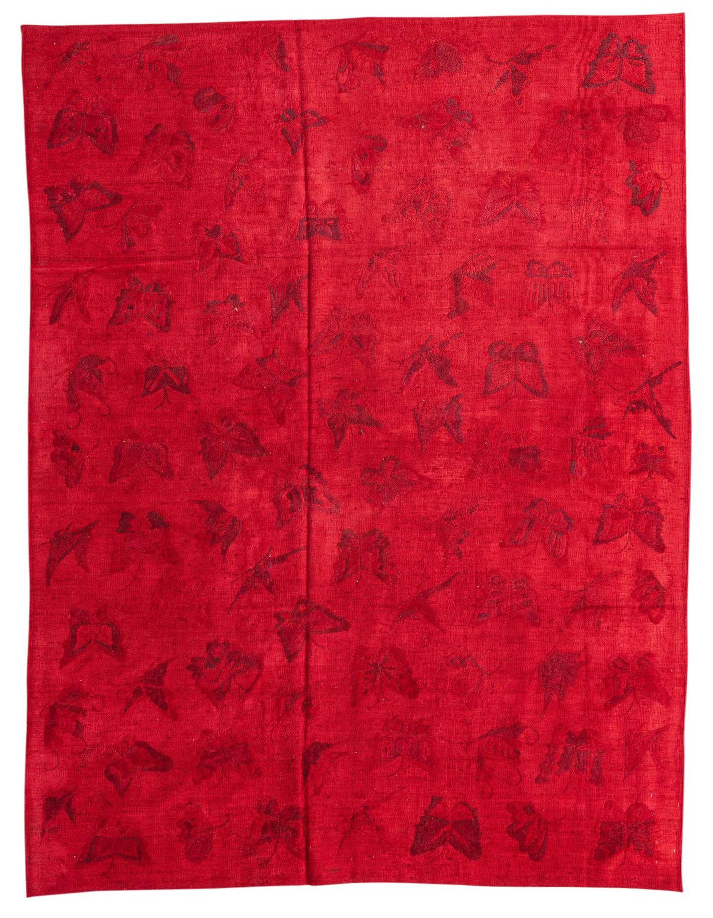 A 6x9 rectangular red Kilim Suzani rug with a subtle tribal leaf pattern, suitable for a living room.