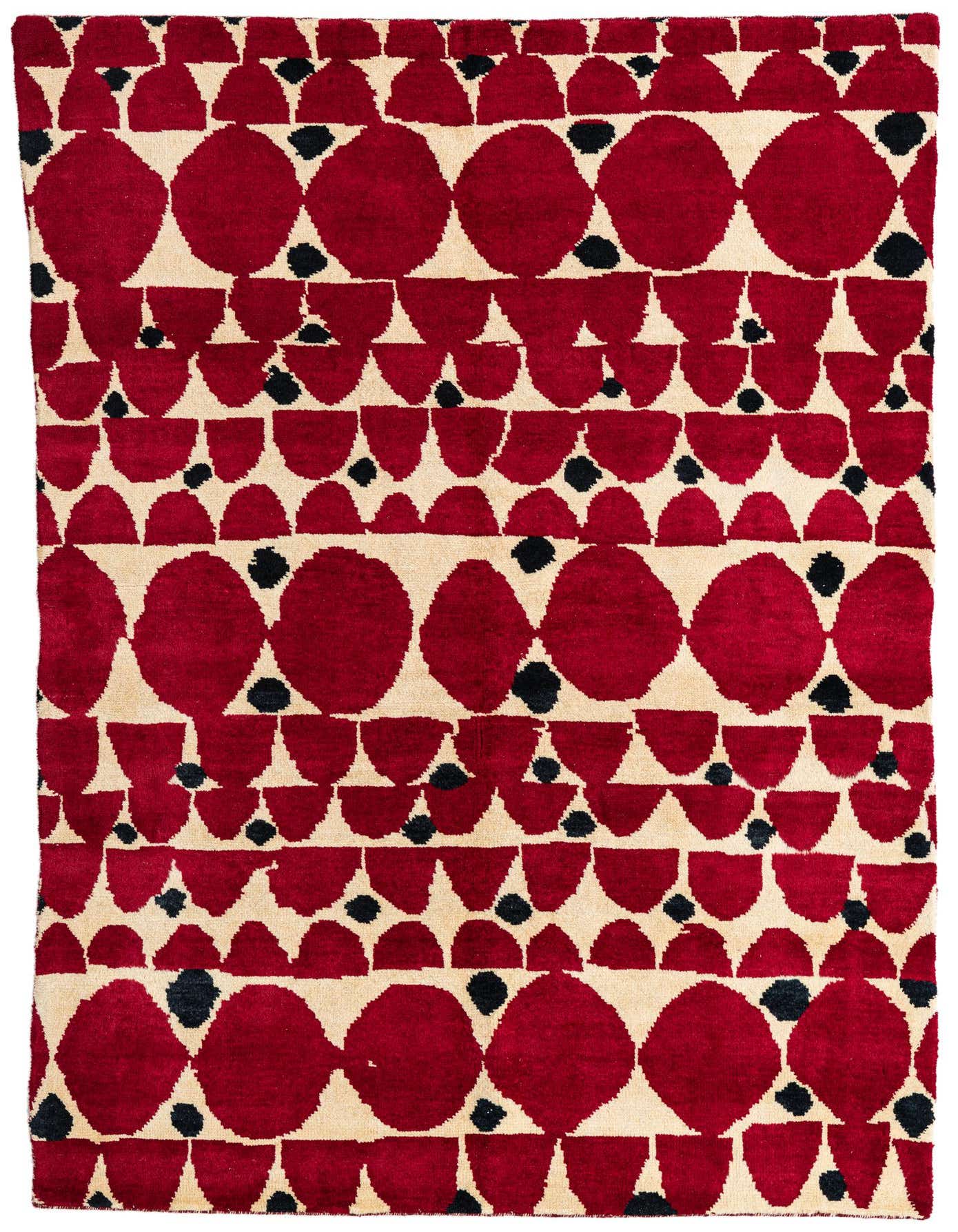 A 5x8 rectangular red, cream, and black tribal shag rug with large red ovals and smaller red half-circles on a cream background, accented with small black dots.