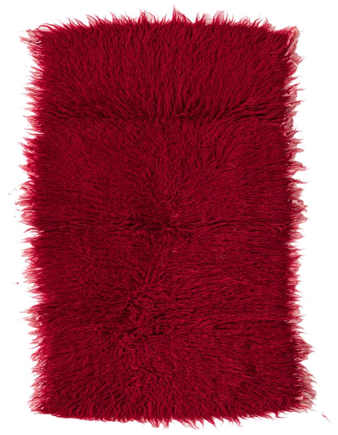 A rectangular 3x5 red shag rug with a thick, plush pile and a slightly uneven, handmade edge, suitable for indoor use.