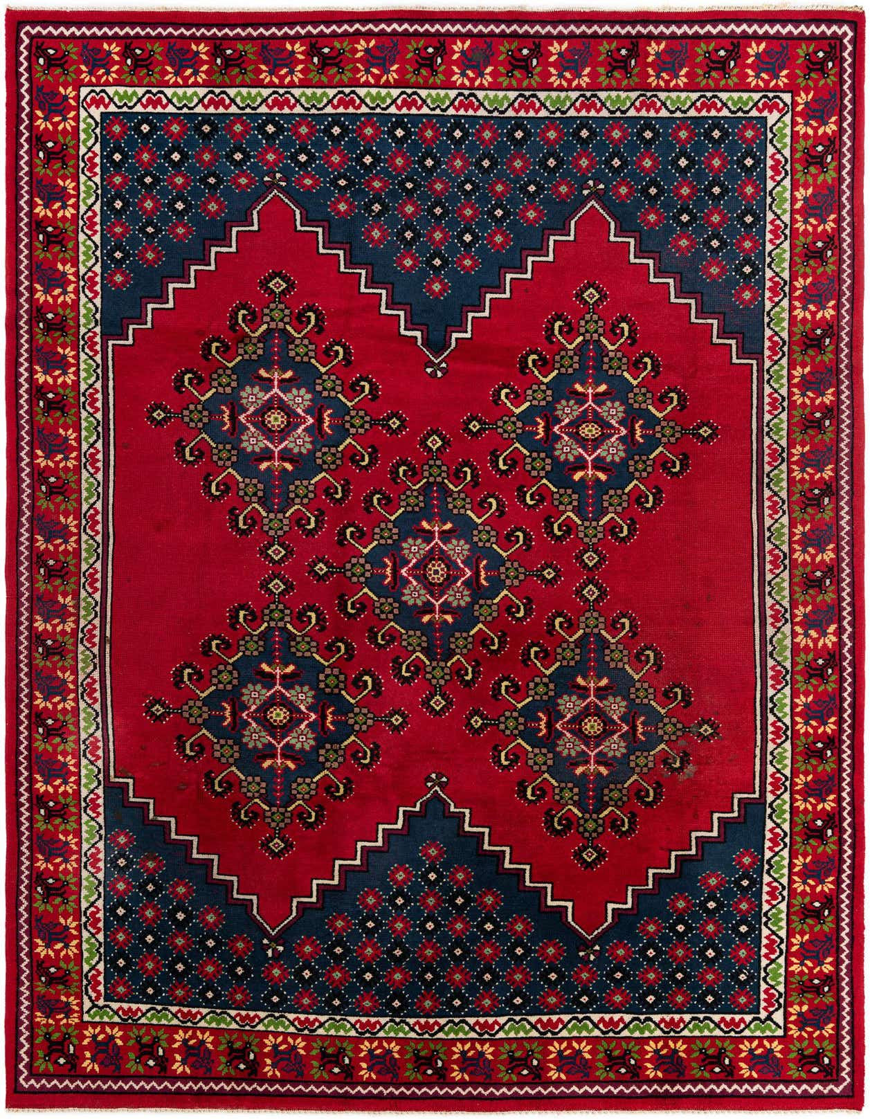 A 7x10 rectangular red wool shag rug with a bold tribal pattern, featuring navy blue geometric shapes and intricate floral motifs, perfect for a living room.