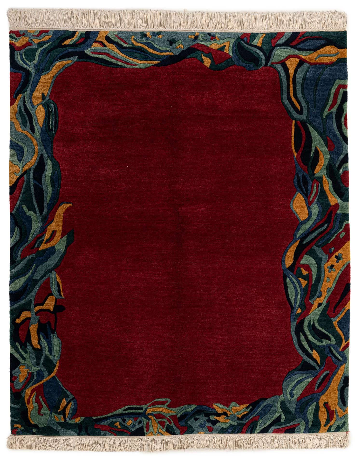 A 5x7 rectangular red wool rug with a modern abstract border in shades of blue, green, and gold, featuring a medium pile.
