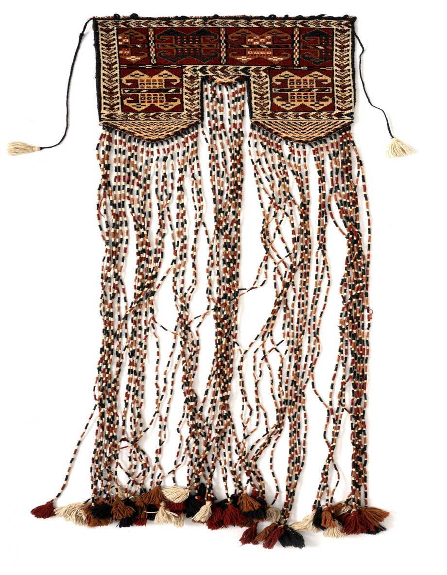 A handmade 1x2 rectangular Persian rug from the Vorhang collection, featuring rich reds and intricate patterns with decorative tassels.