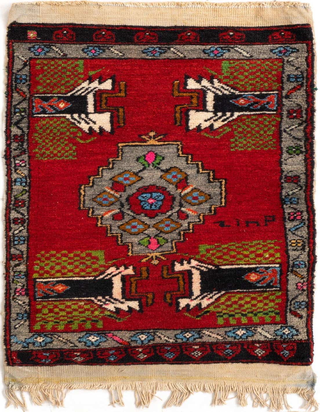 A 2x3 rectangular Yastik rug in vibrant red with a central gray geometric medallion and stylized animal motifs.