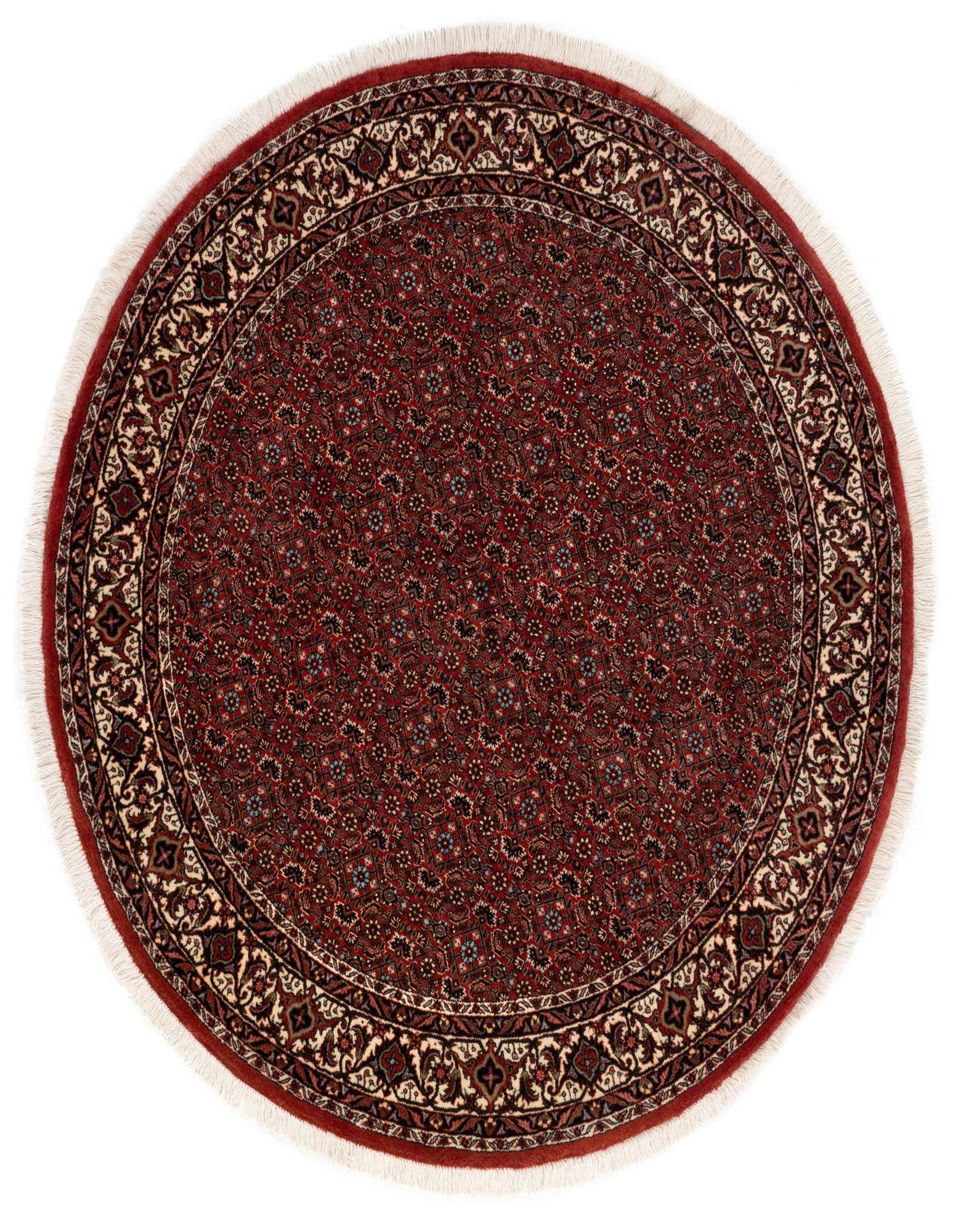 A 5' 0 round red Persian rug with a detailed floral and medallion pattern and fringed edges.