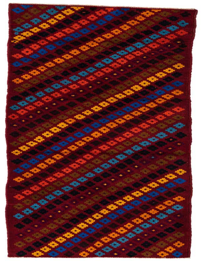 A 9 ft Balouch runner rug in rich red with diagonal rows of colorful tribal diamond patterns in blue, orange, yellow, and black.
